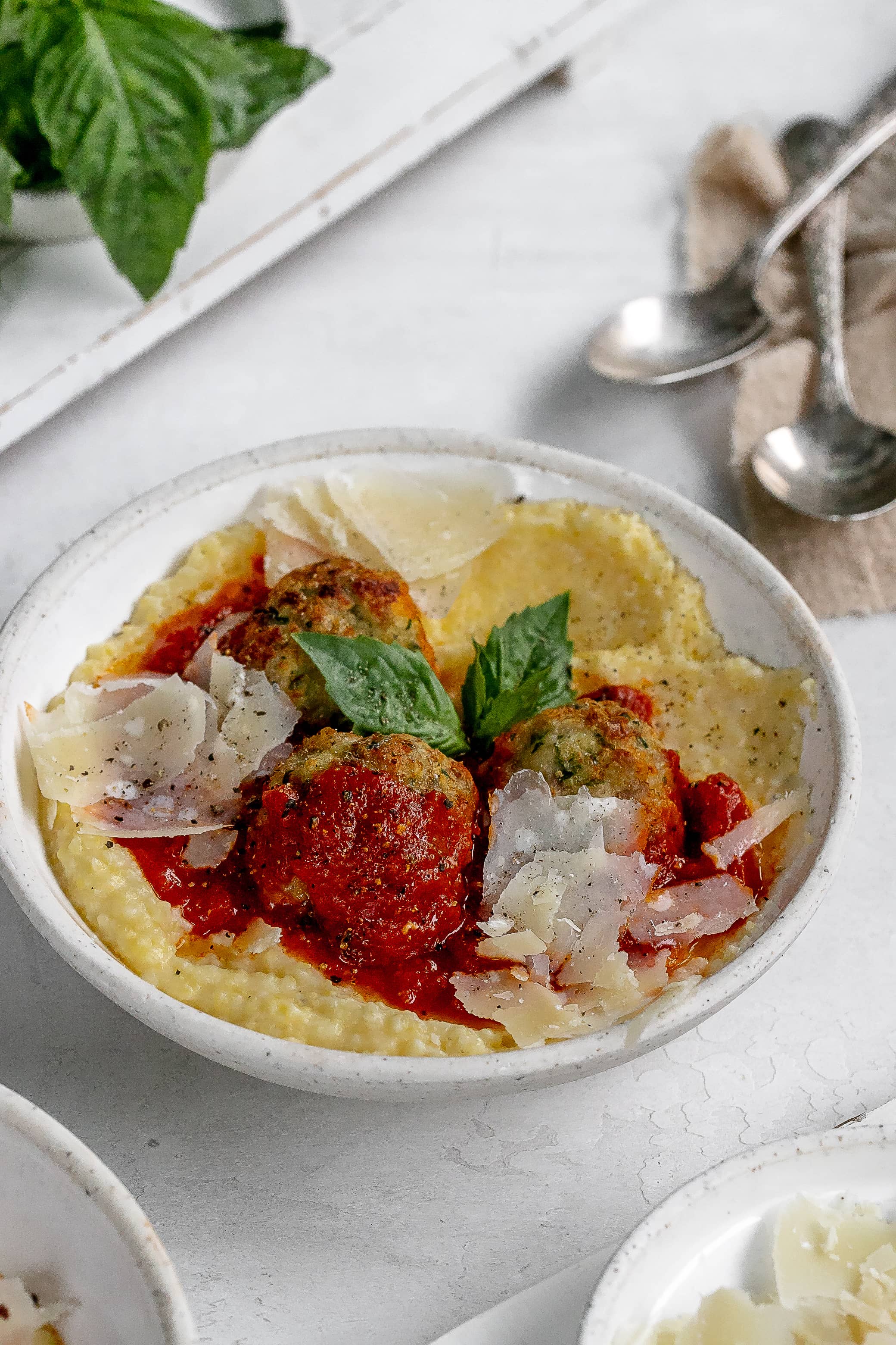 polenta in a bowl with meatballs on top.