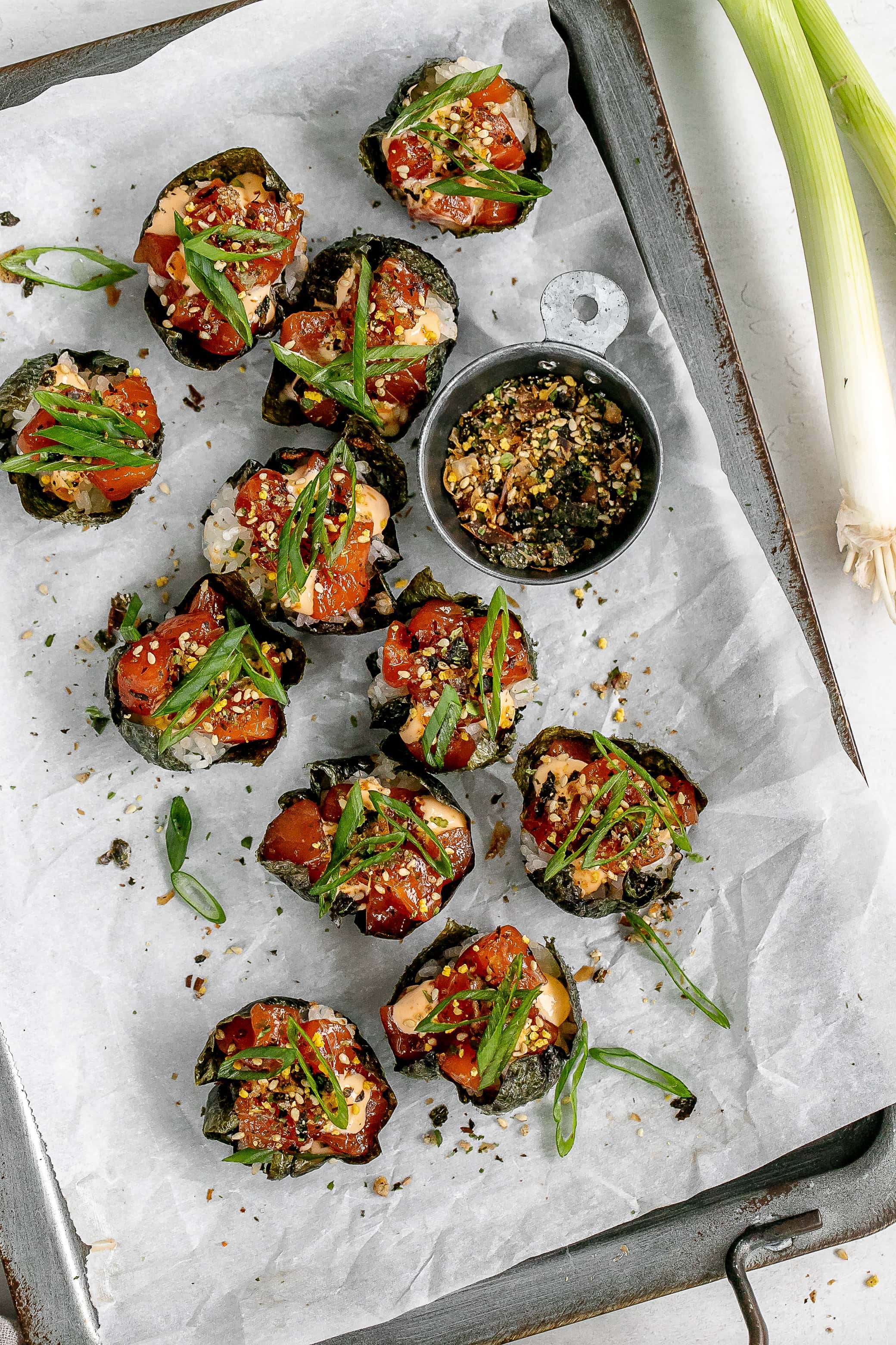 salmon sushi cups on a baking sheet with parchment paper. 