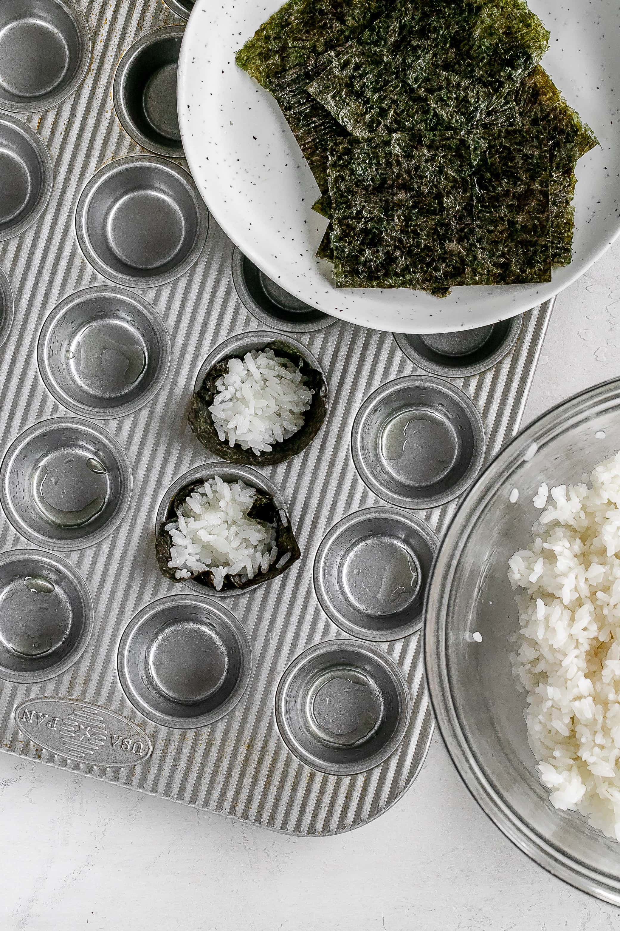 nori and rice in muffin tin.