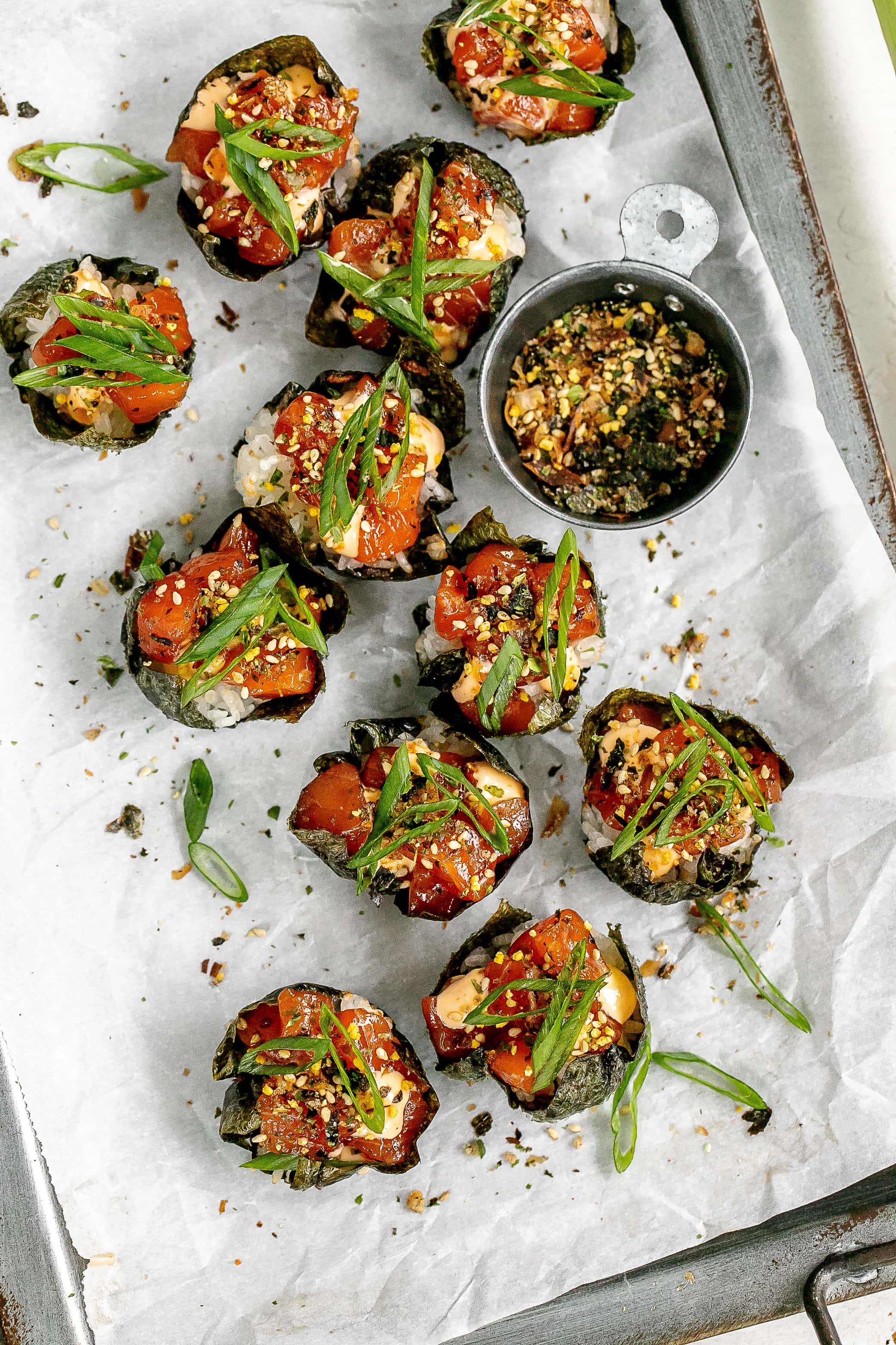 salmon sushi cups on a baking sheet with parchment paper. 