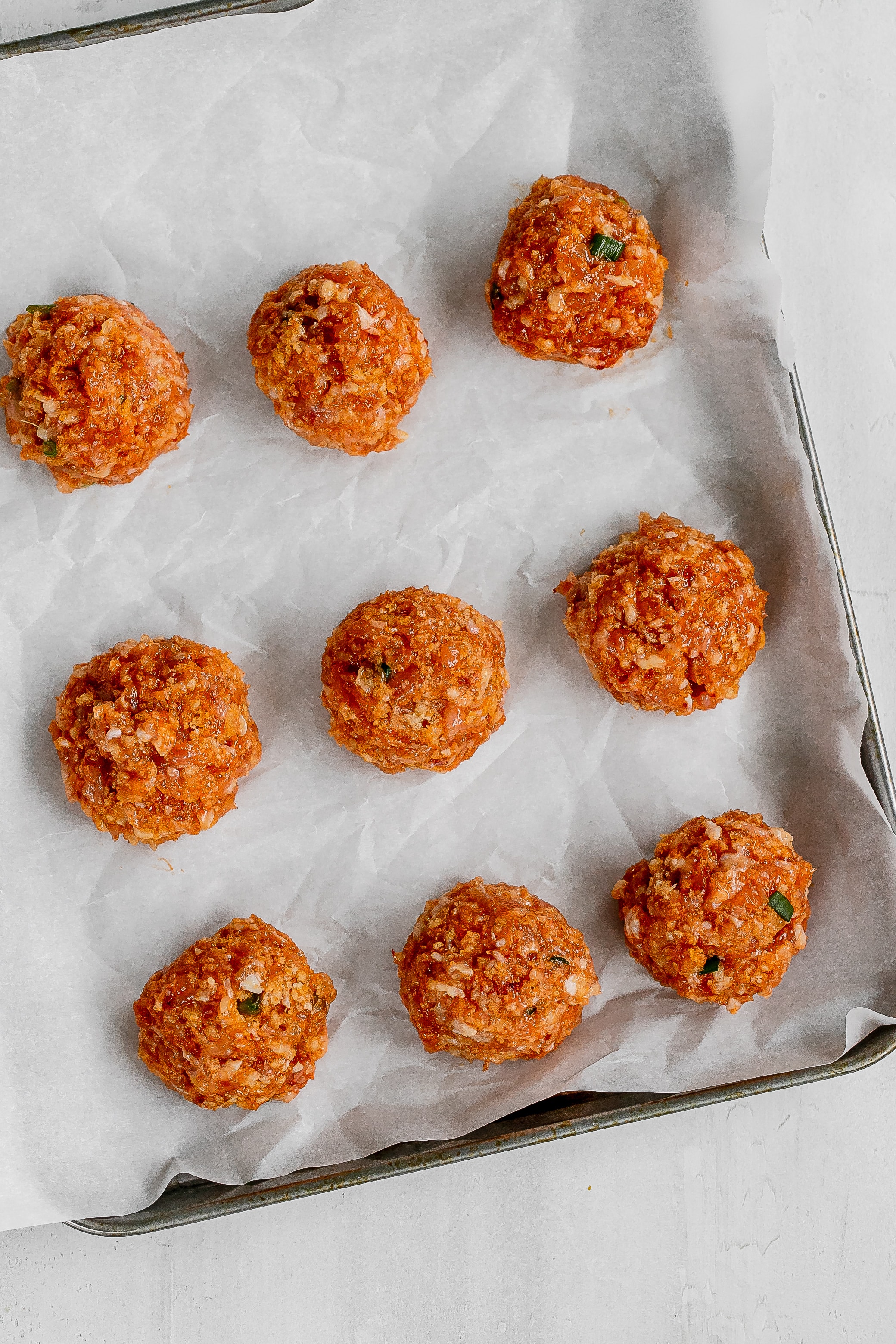 meatballs on baking sheet uncooked. 