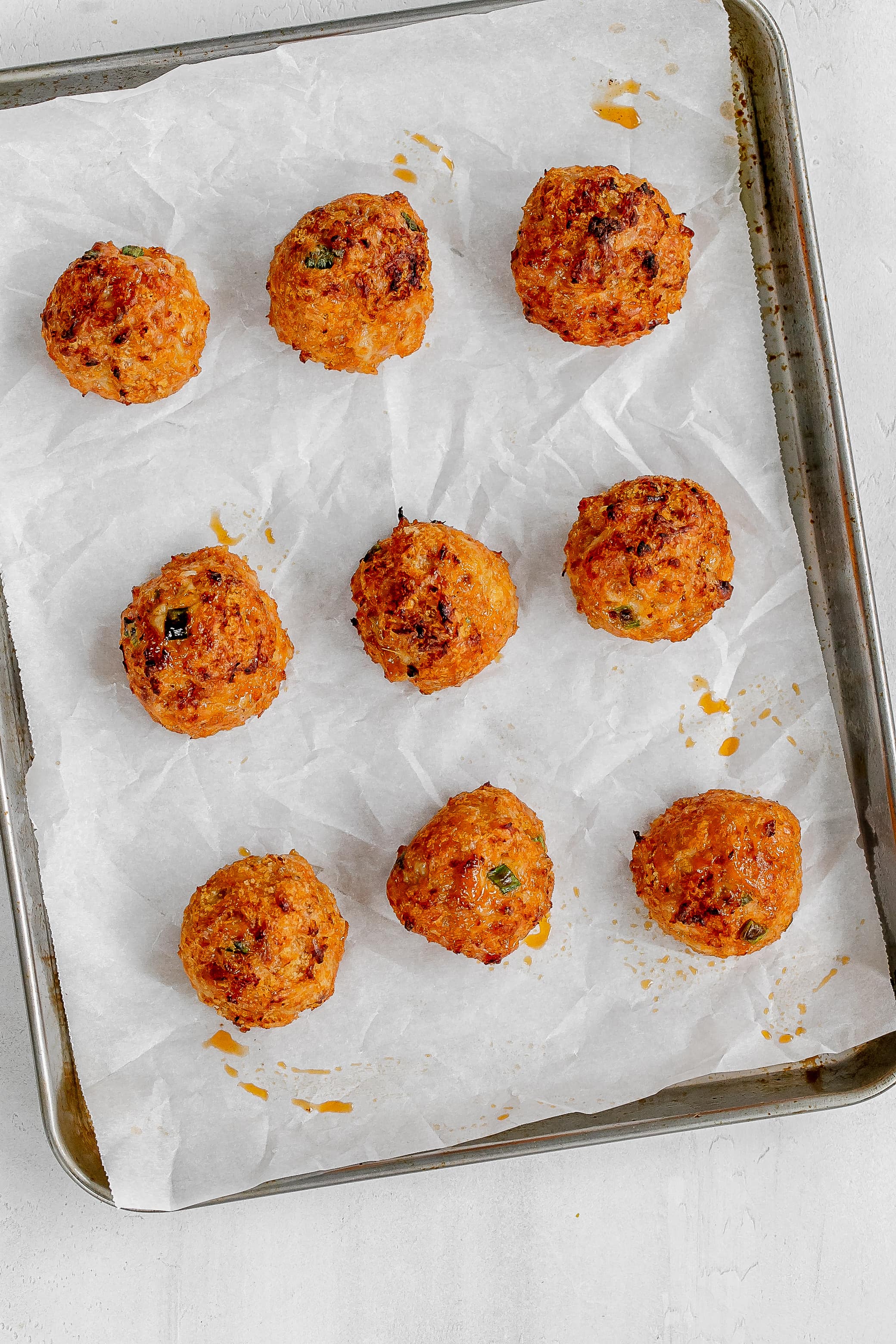 cooked meatballs on baking sheet. 