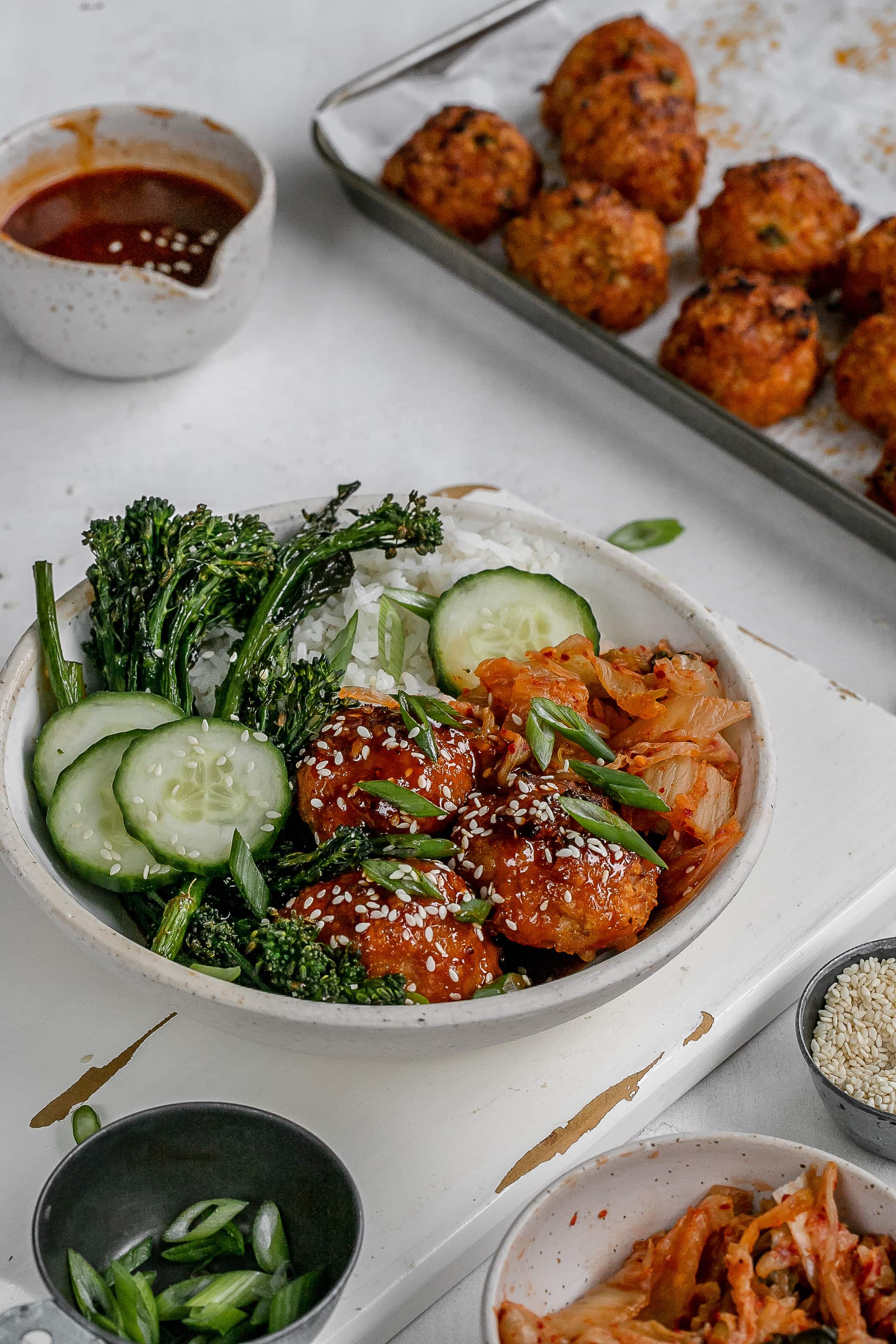 gochujang meatballs in a bowl with rice, veggies and kimchi.