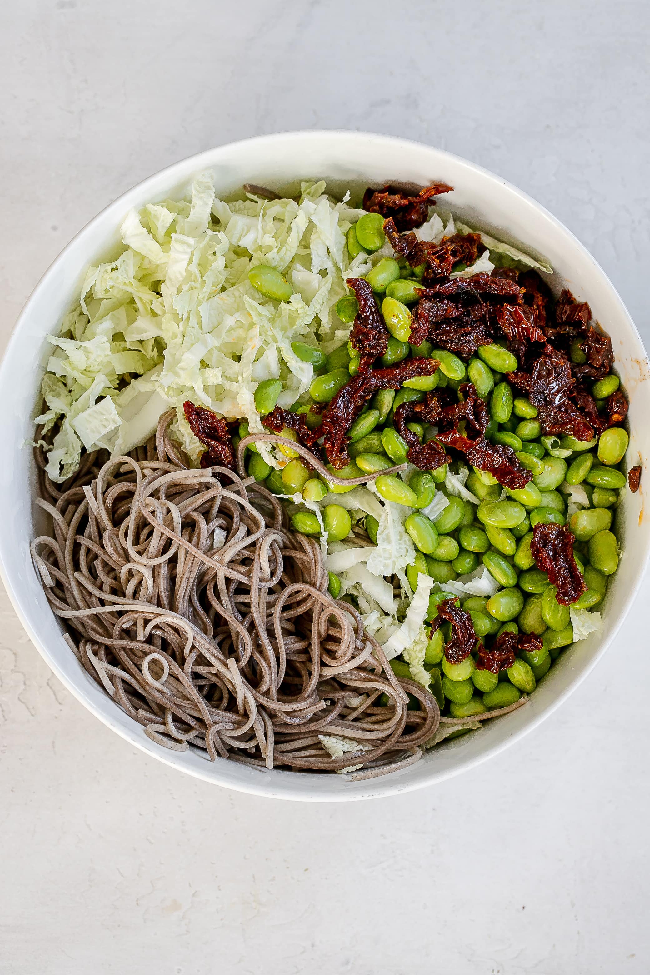 soba noodles in large bowl with ingredients. 