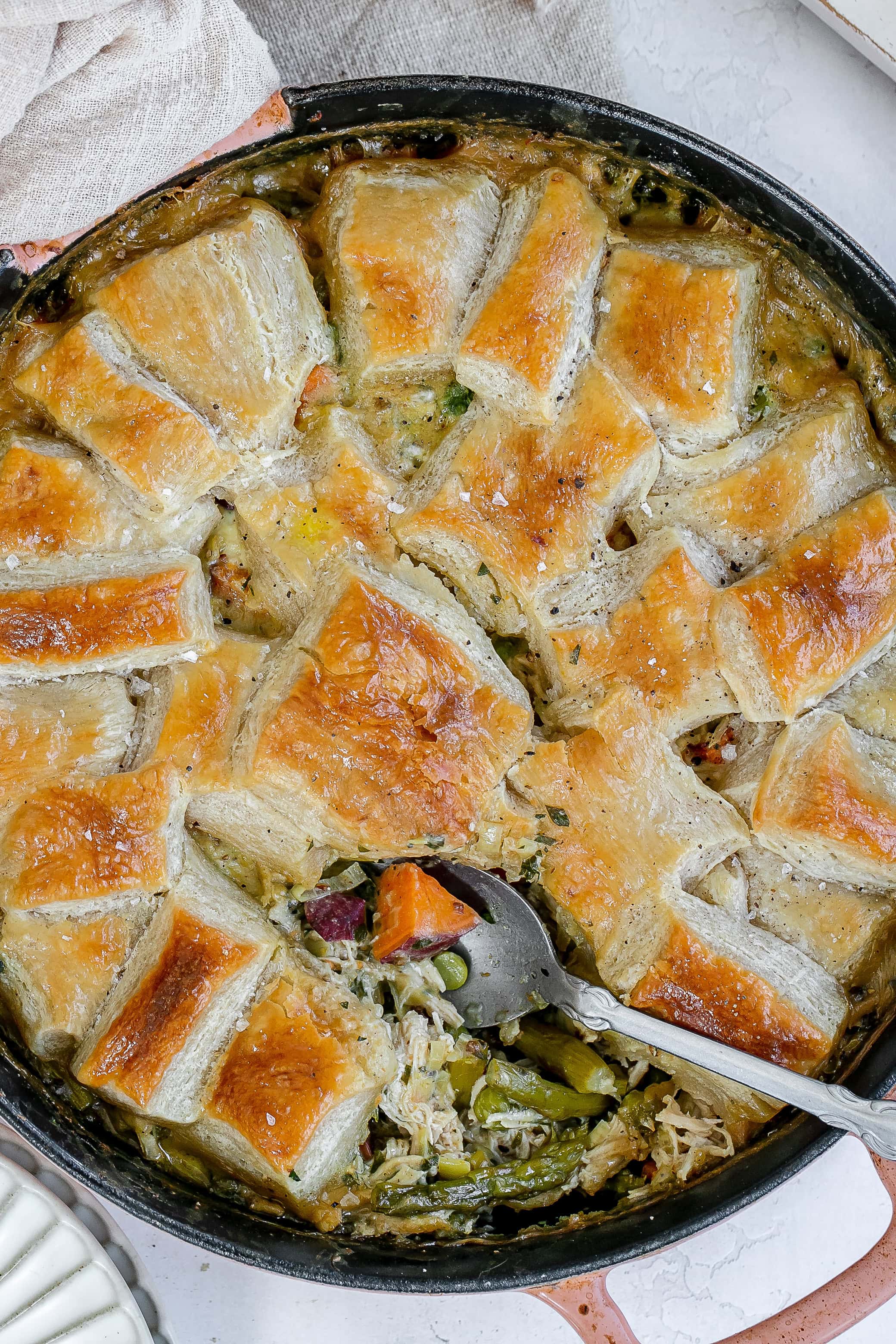 cast iron chicken pot pie with spoon digging in.
