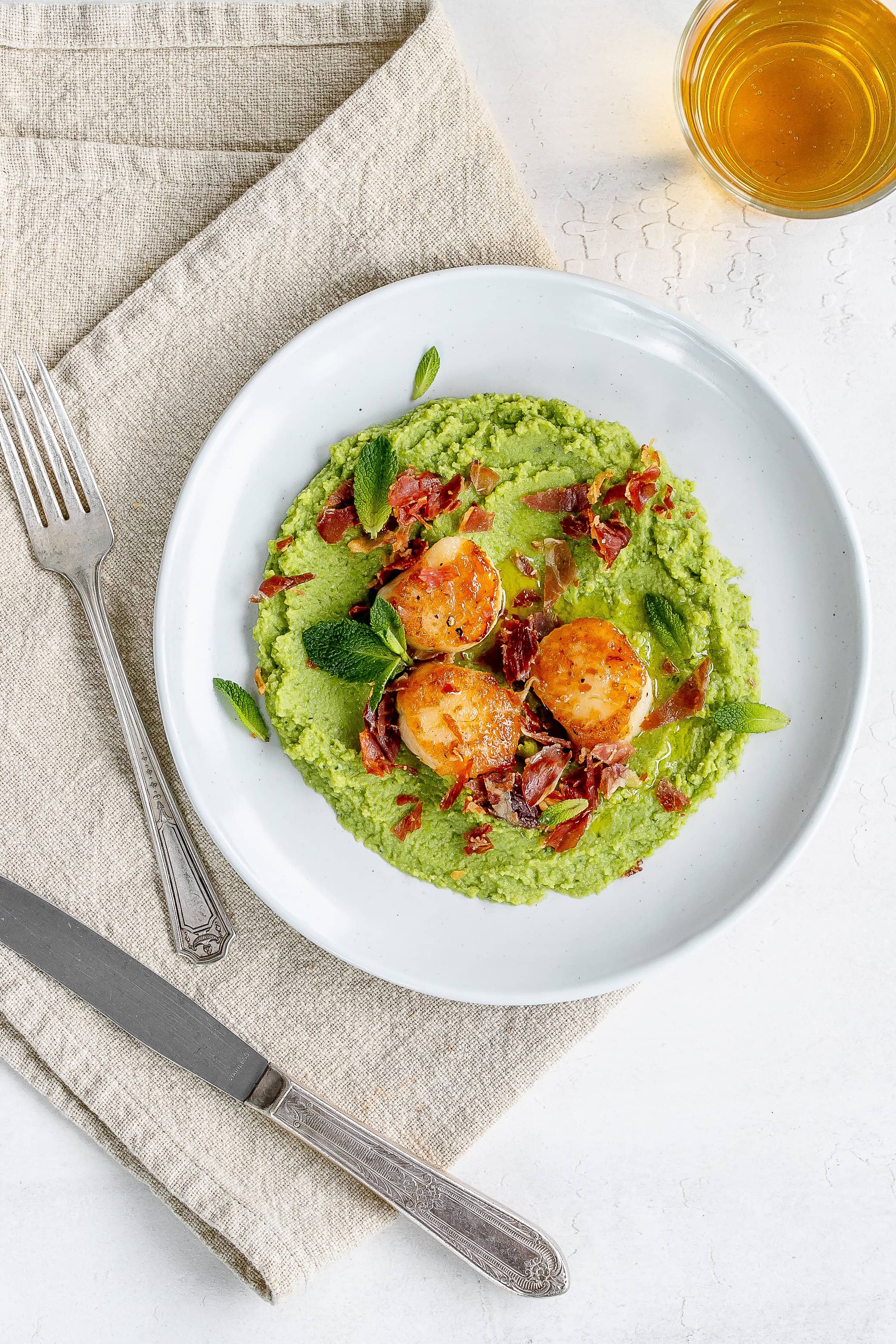 scallops and pea puree on a plate.