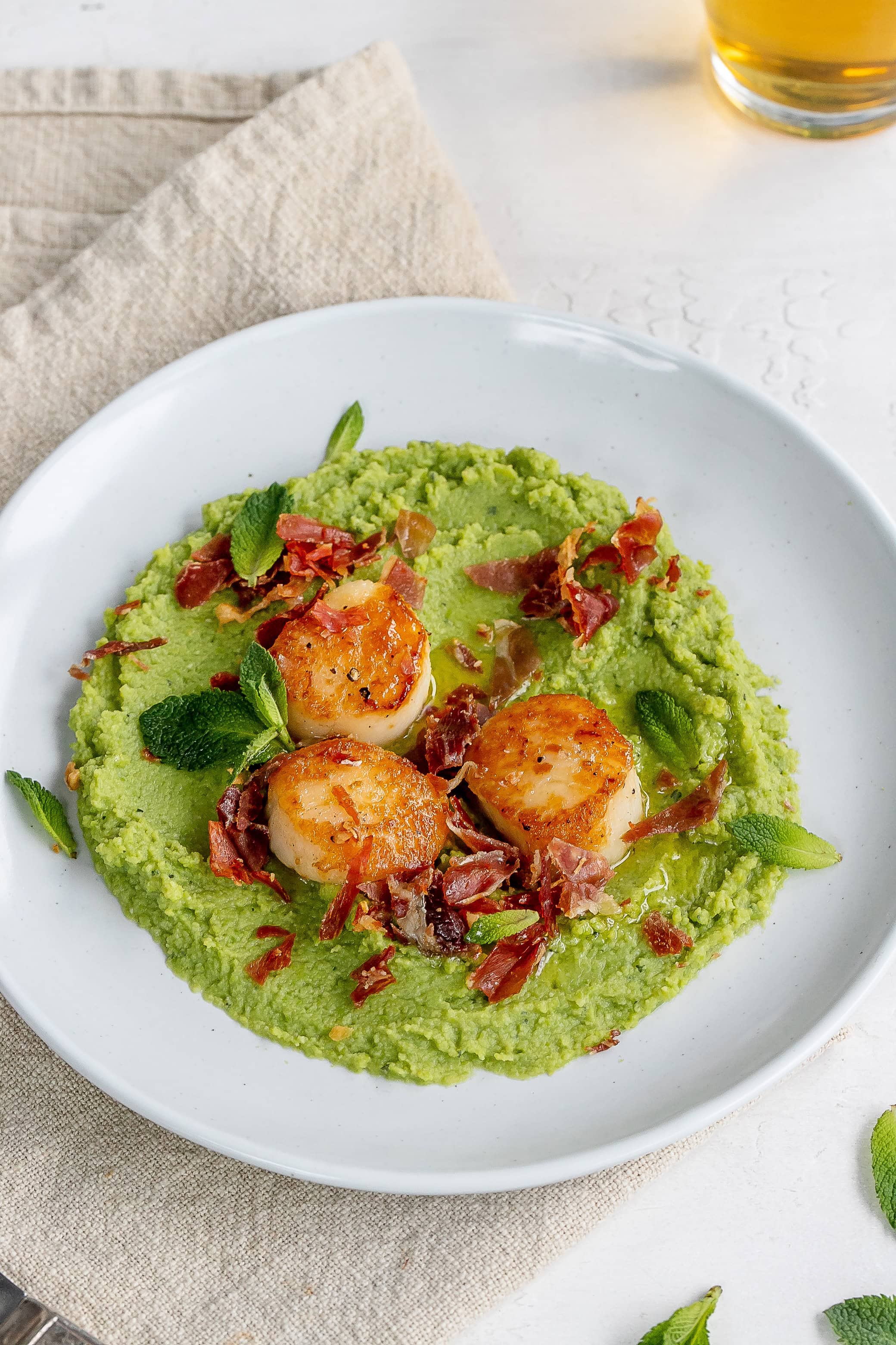 scallops and pea puree on a plate.