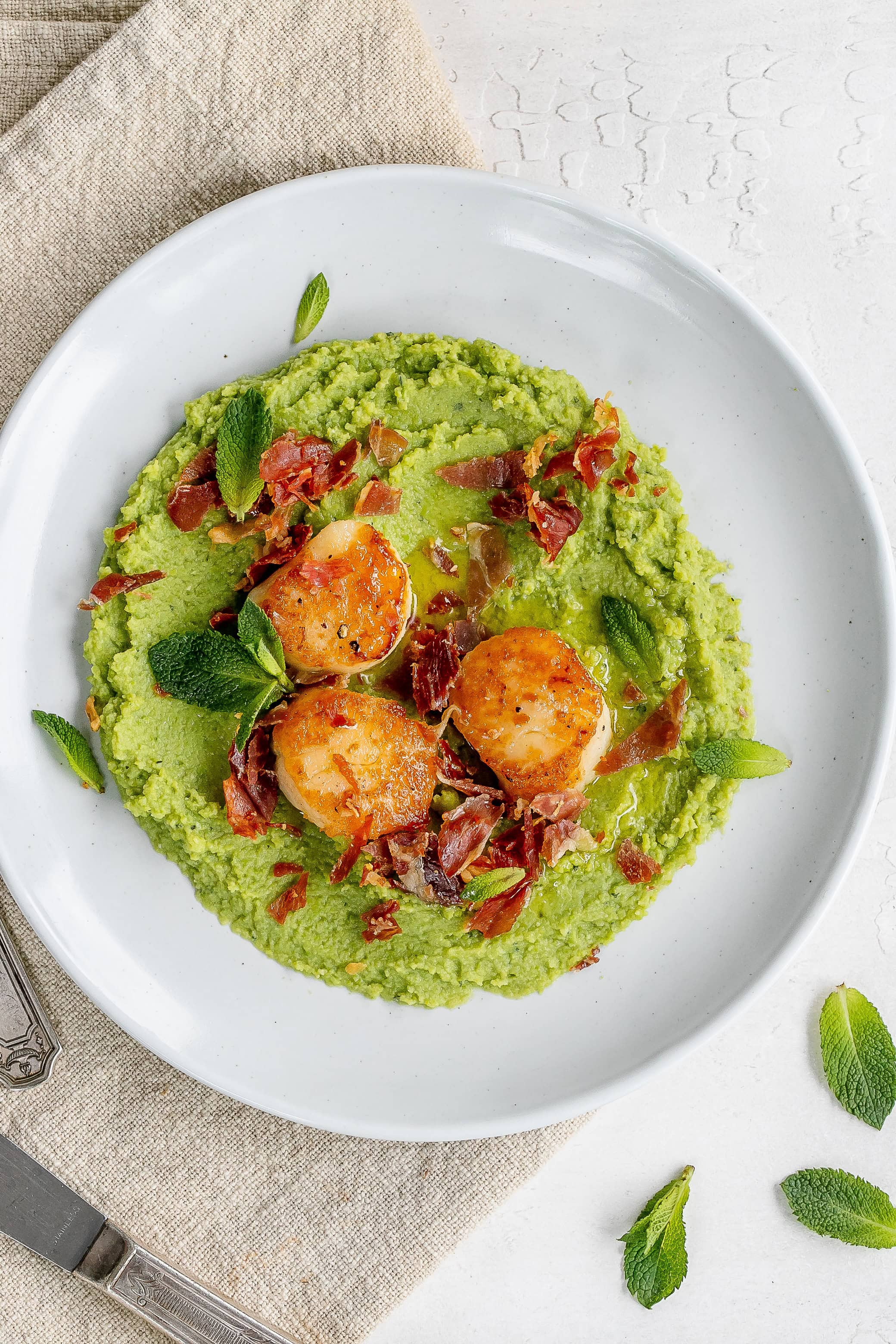 scallops and pea puree on a plate.