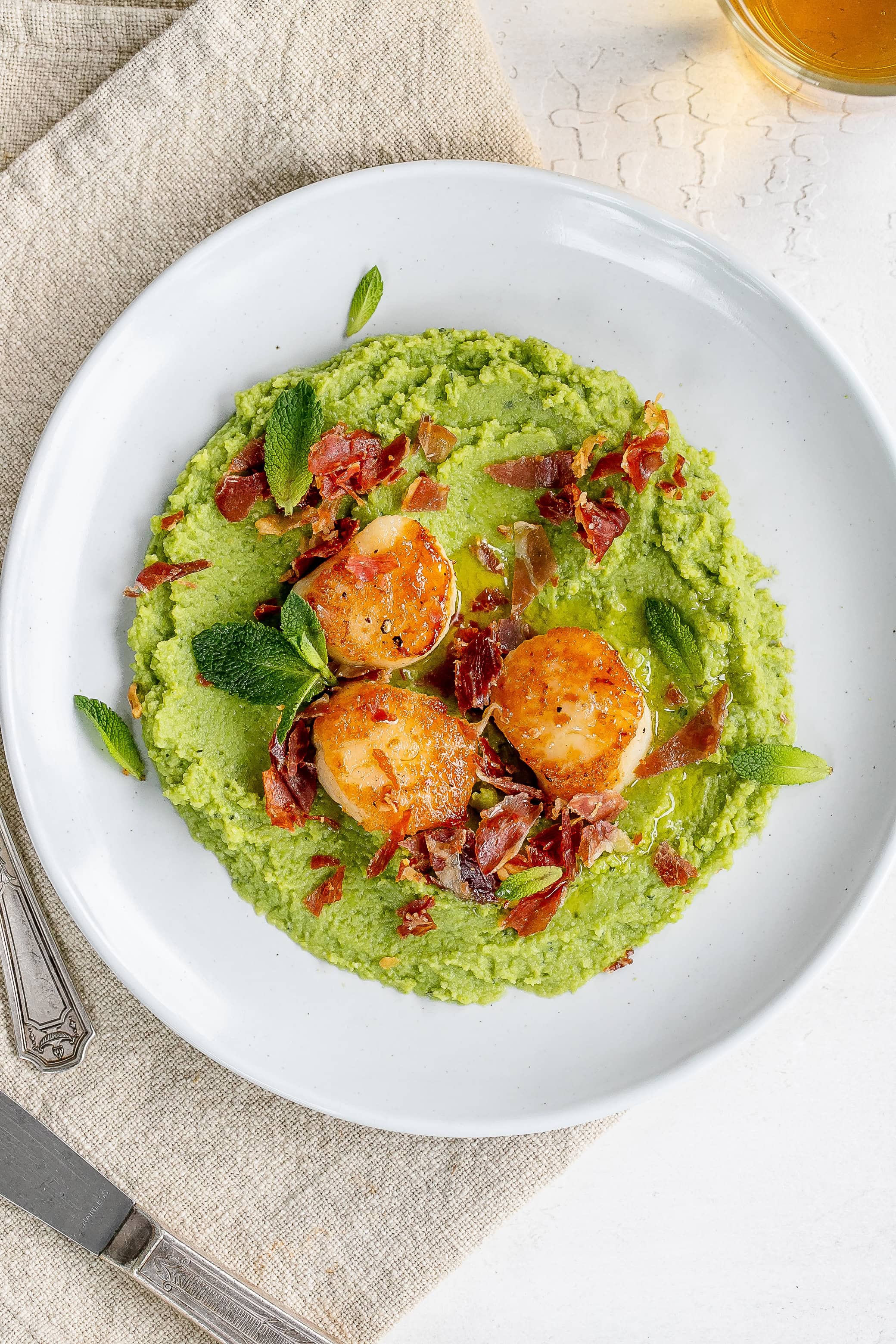 scallops and pea puree on a plate.