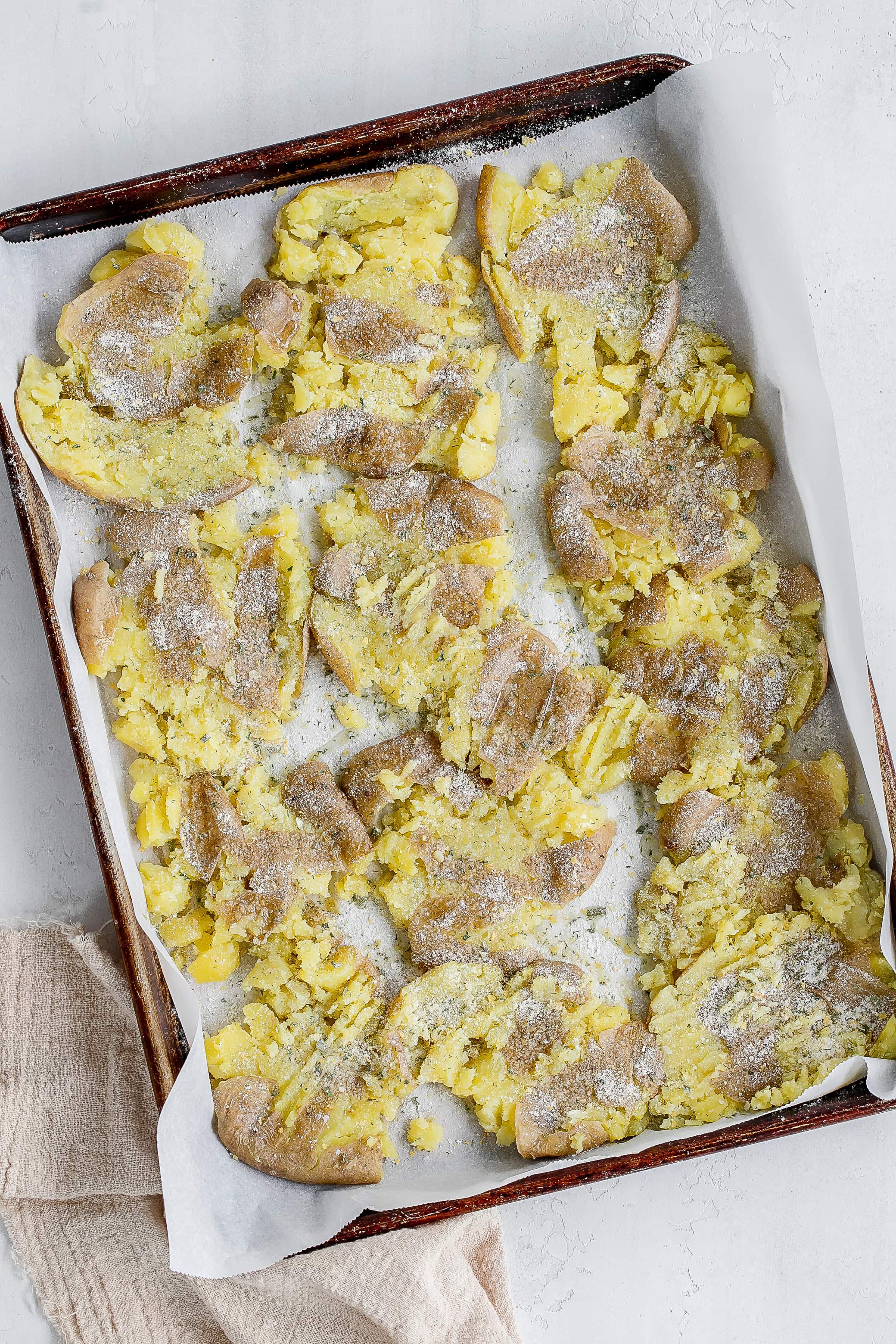 smashed potatoes on baking sheet with salt and ranch seasoning. 