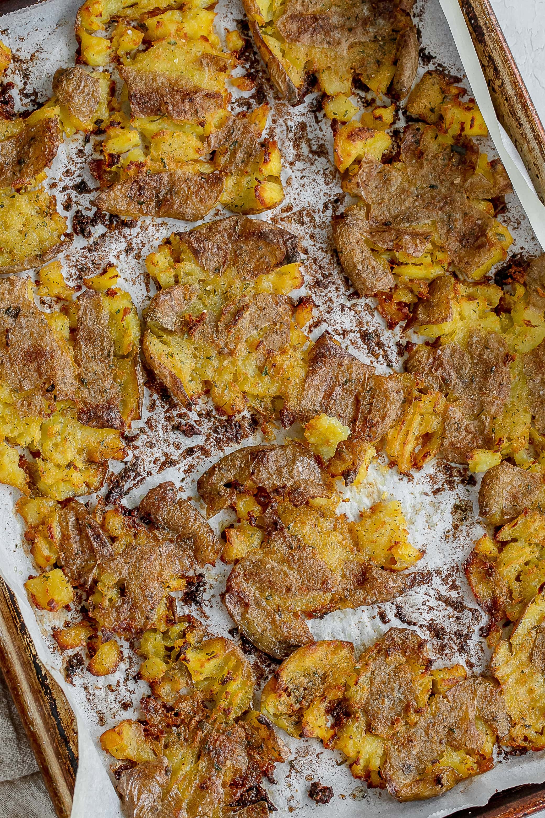 baked smashed potatoes on baking sheet. 
