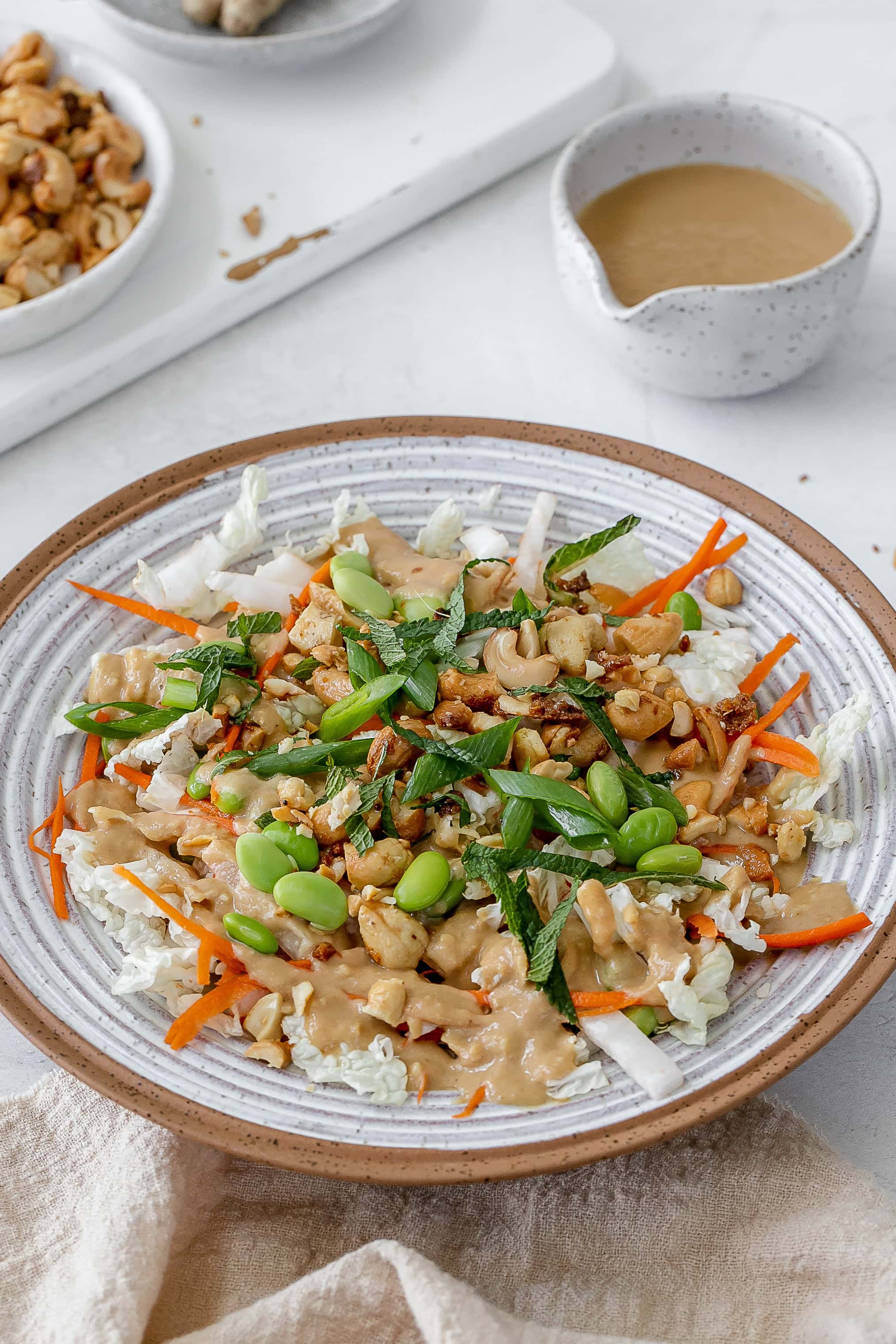 miso slaw in bowl with dressing on the side. 