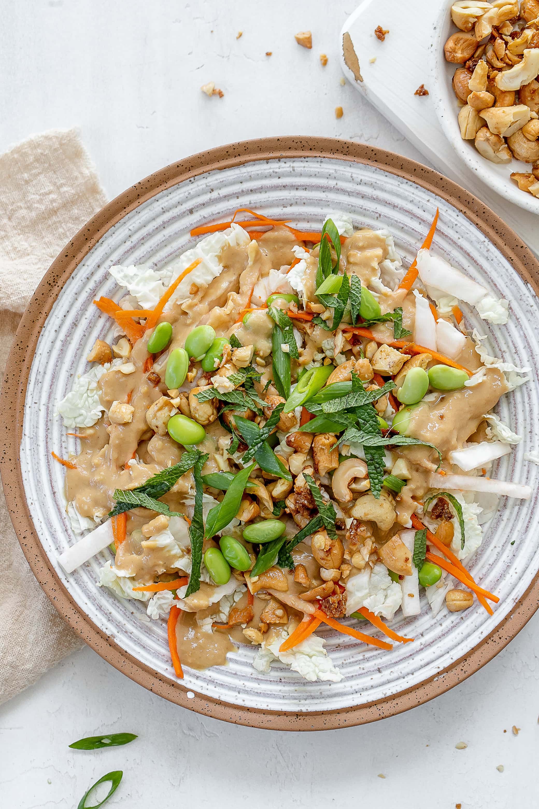miso slaw in bowl with dressing on the side. 