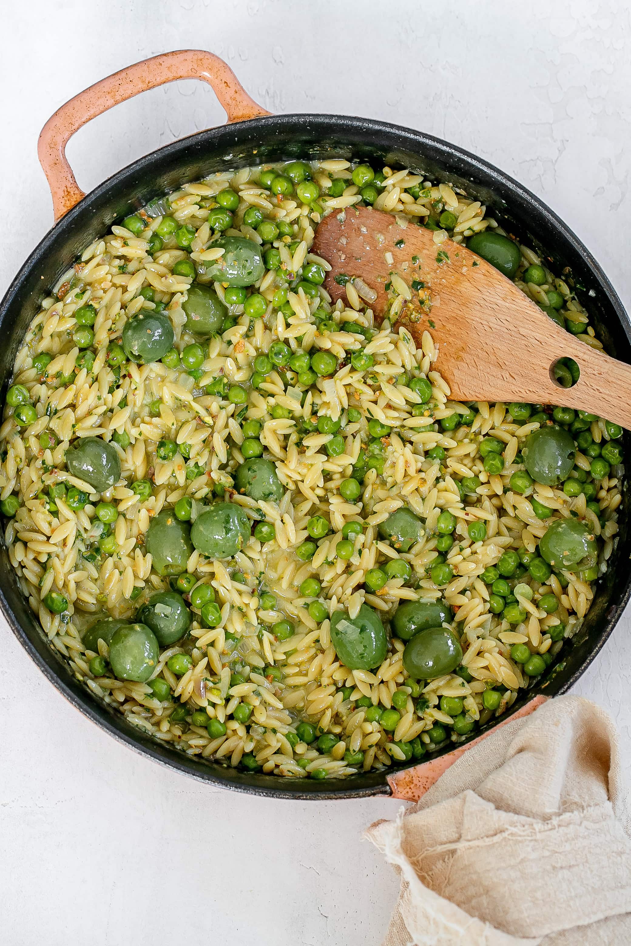 orzo, peas and olives cooked in skillet with pesto. 