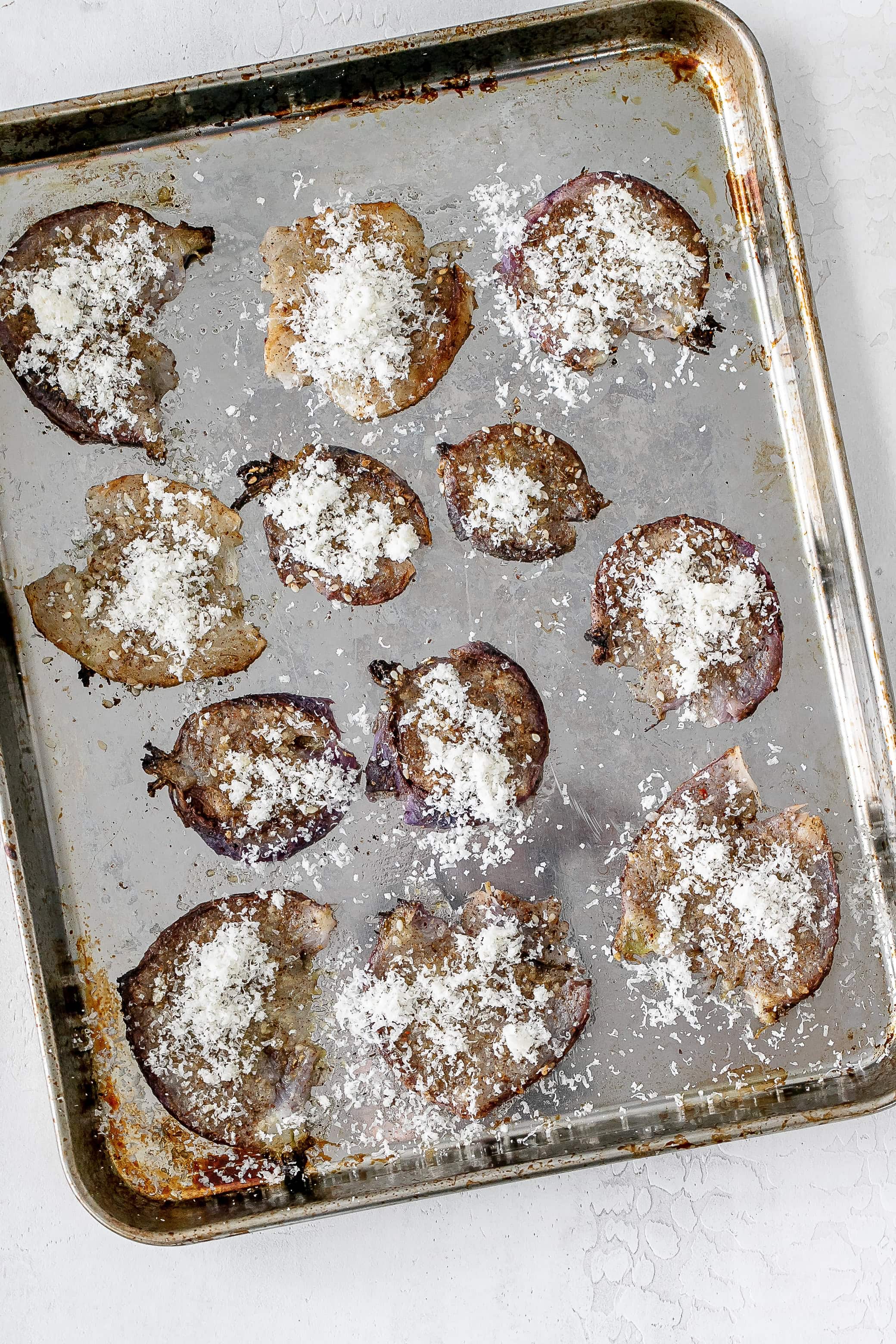 smashed radishes on baking sheet with parmesan. 