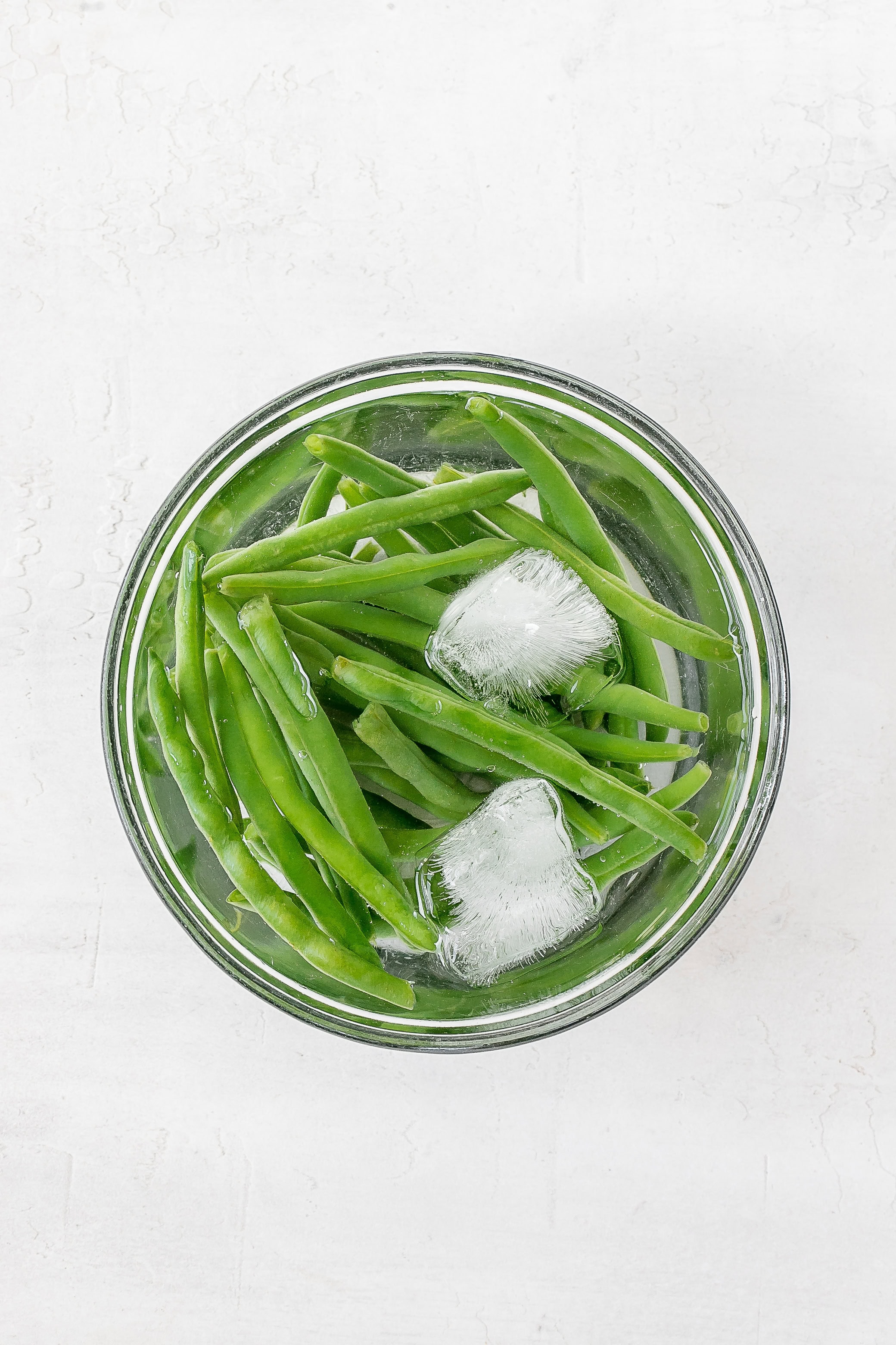 green beans in bowl filled with ice. 