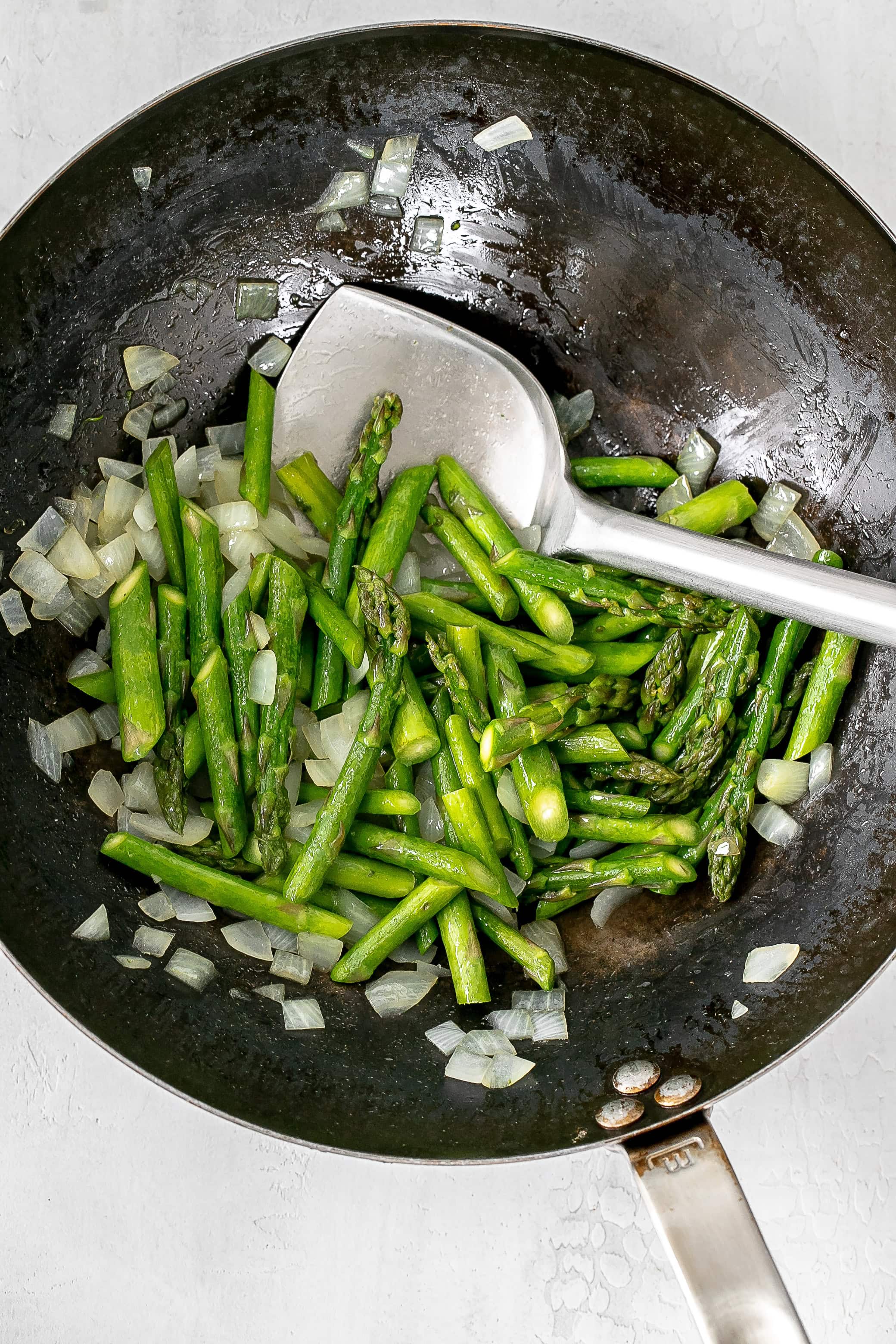 asparagus and onion in a wok.