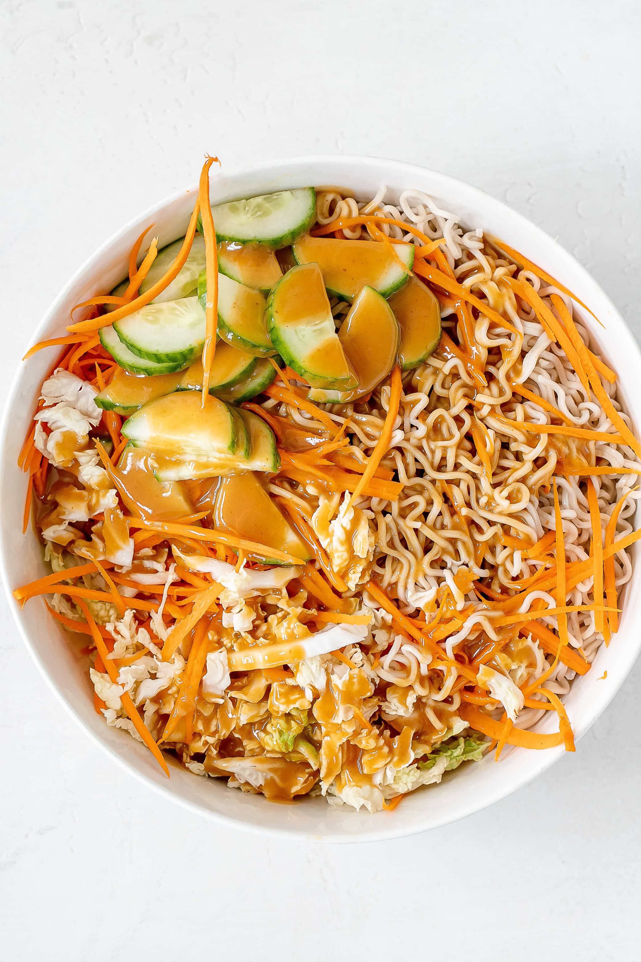 cold ramen noodle salad in bowl with dressing.