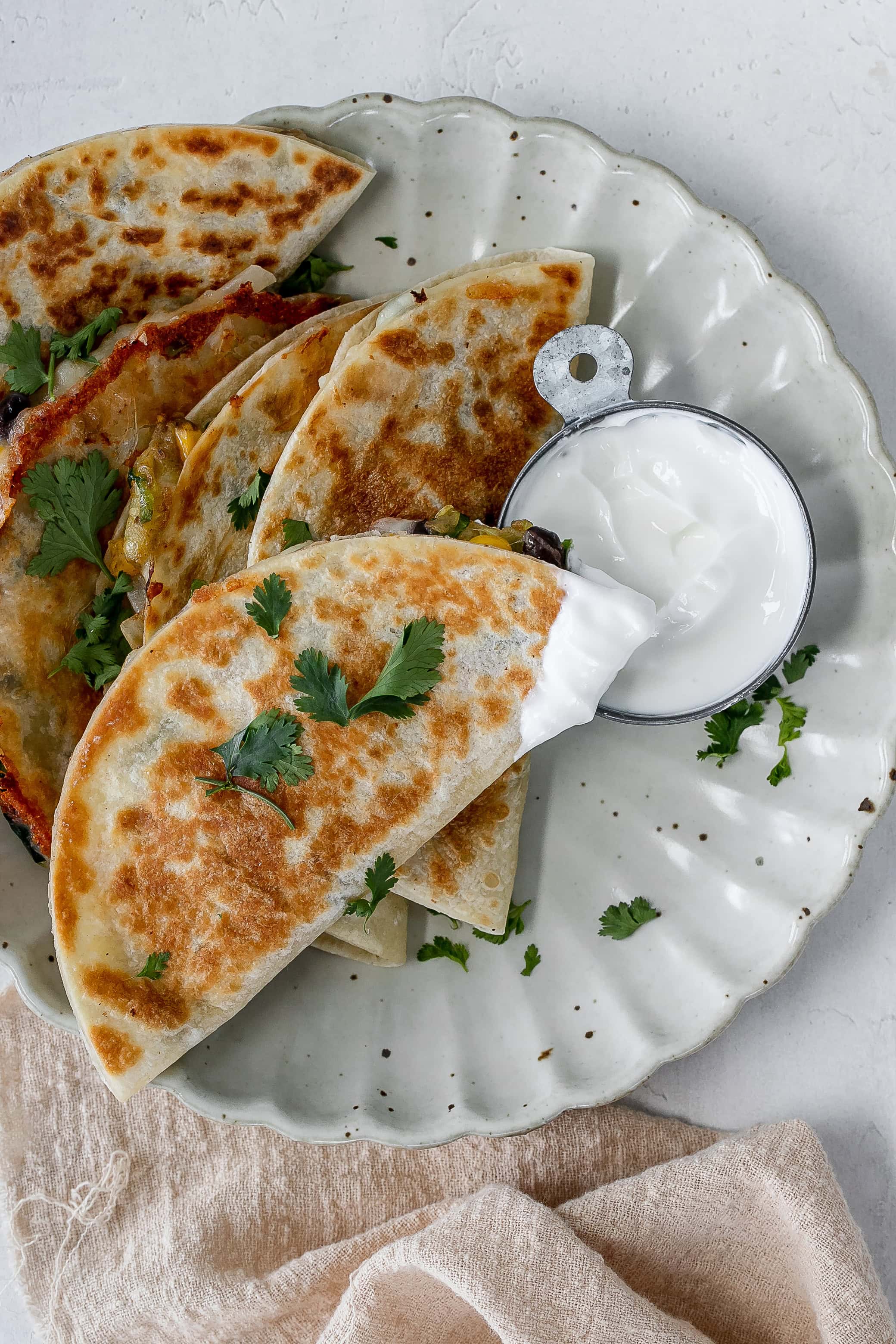 zucchini quesadillas on a plate with yogurt dip.