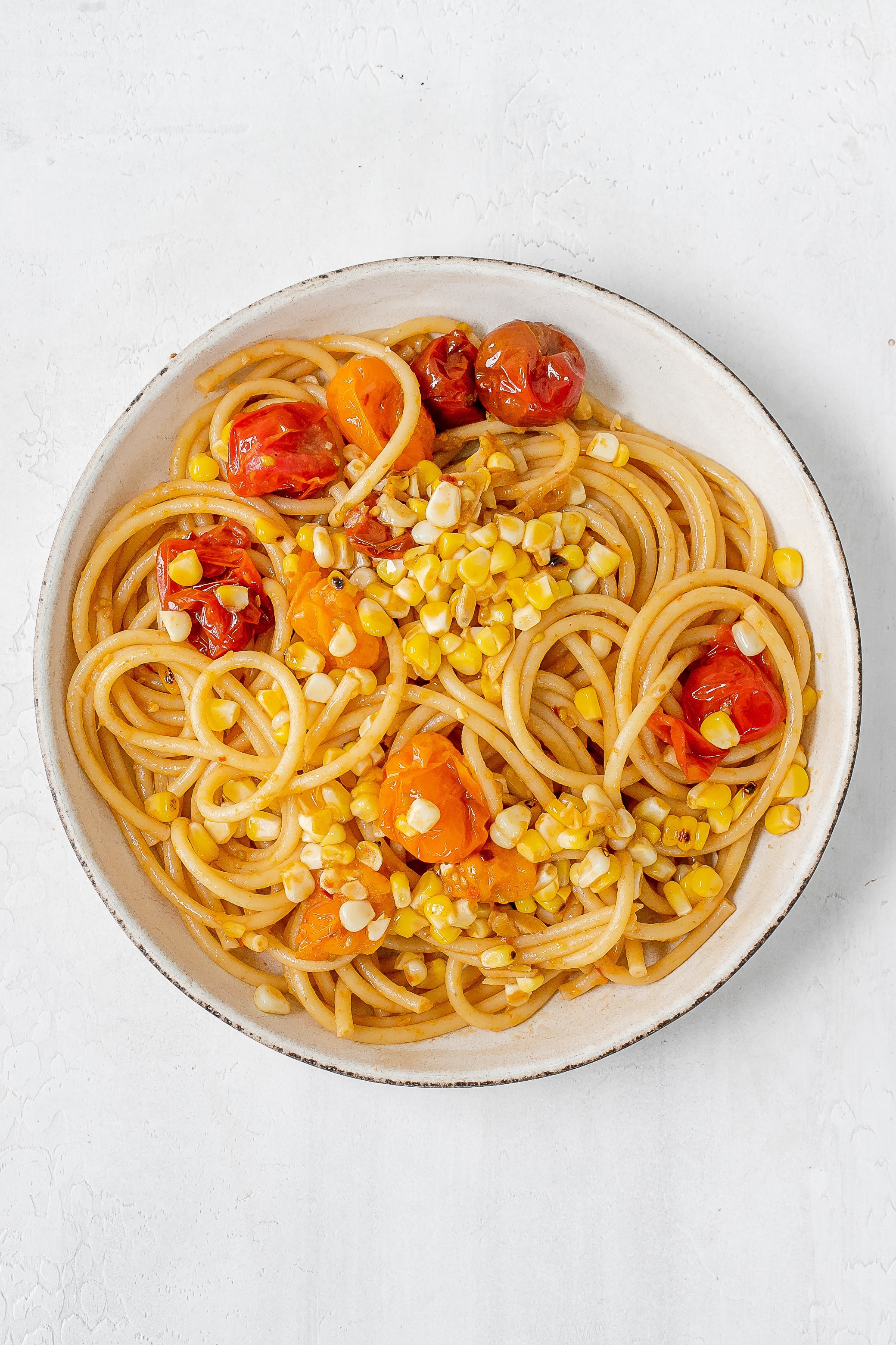 tomato and corn pasta in a pasta bowl.