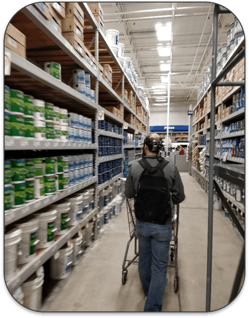 A man with eye tracking equipment attached to his headwalking down a supermarket aisle.