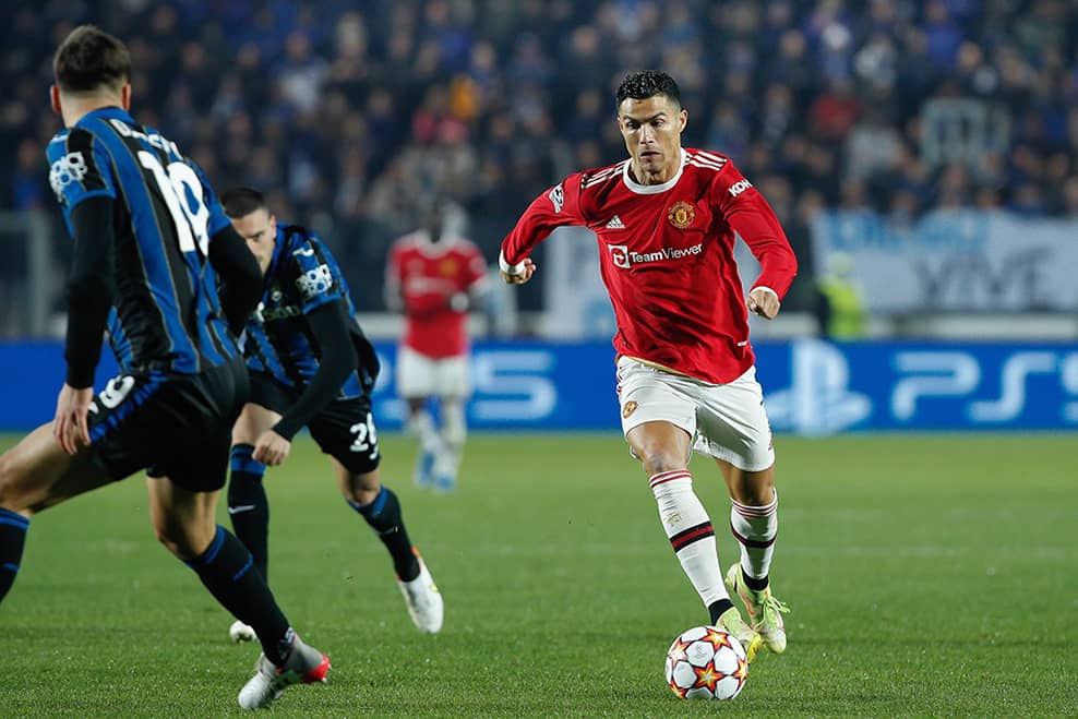 Christiano Ronaldo playing football for Manchester United sprinting past another player