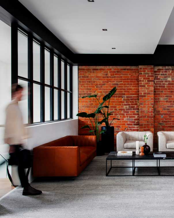 Blurred man entering reception area with an exposed brick wall