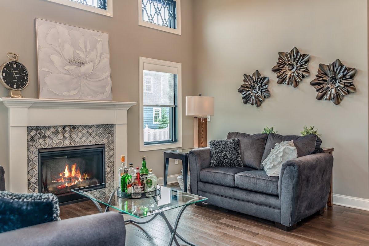 fireplace in tall ceiling room with grey couches