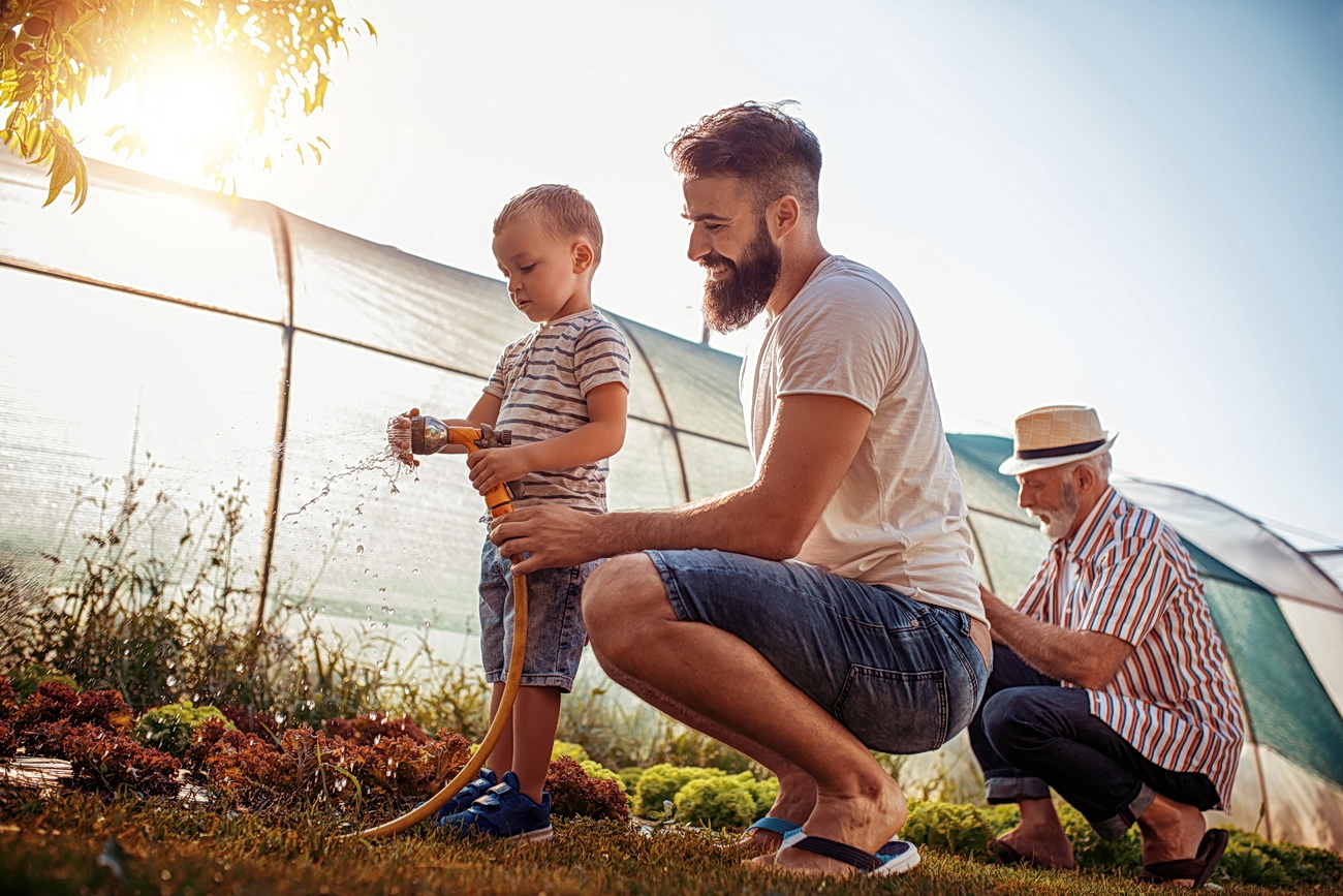 Young father with his son working in the garden,enjoying together.