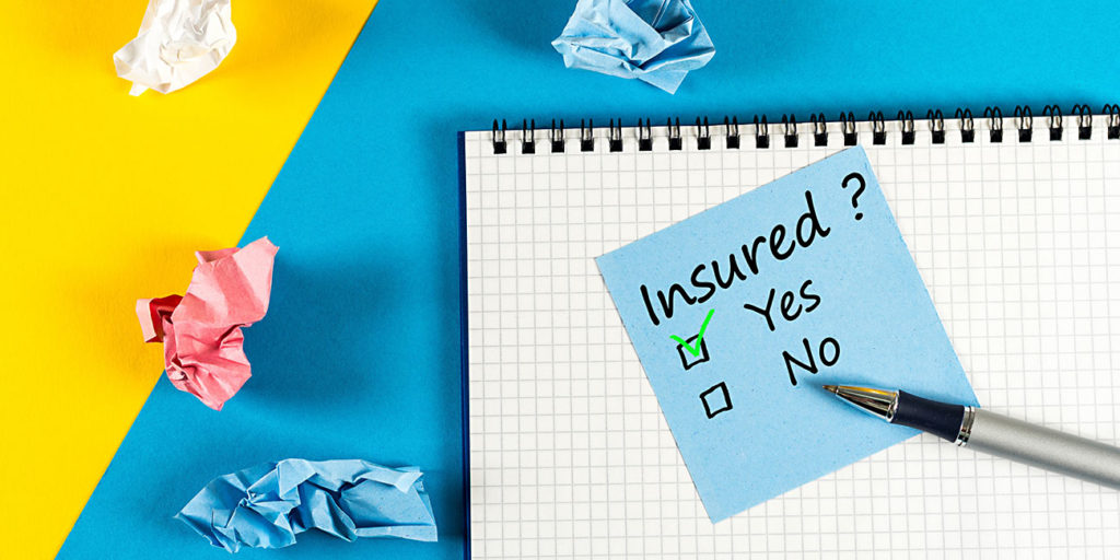 Survey with question Insured, Yes or no. Message at notepad at yellow and blue table