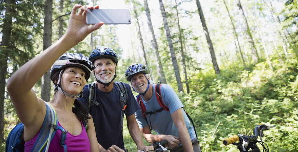 Mountain biking friends taking selfie camera phone woods