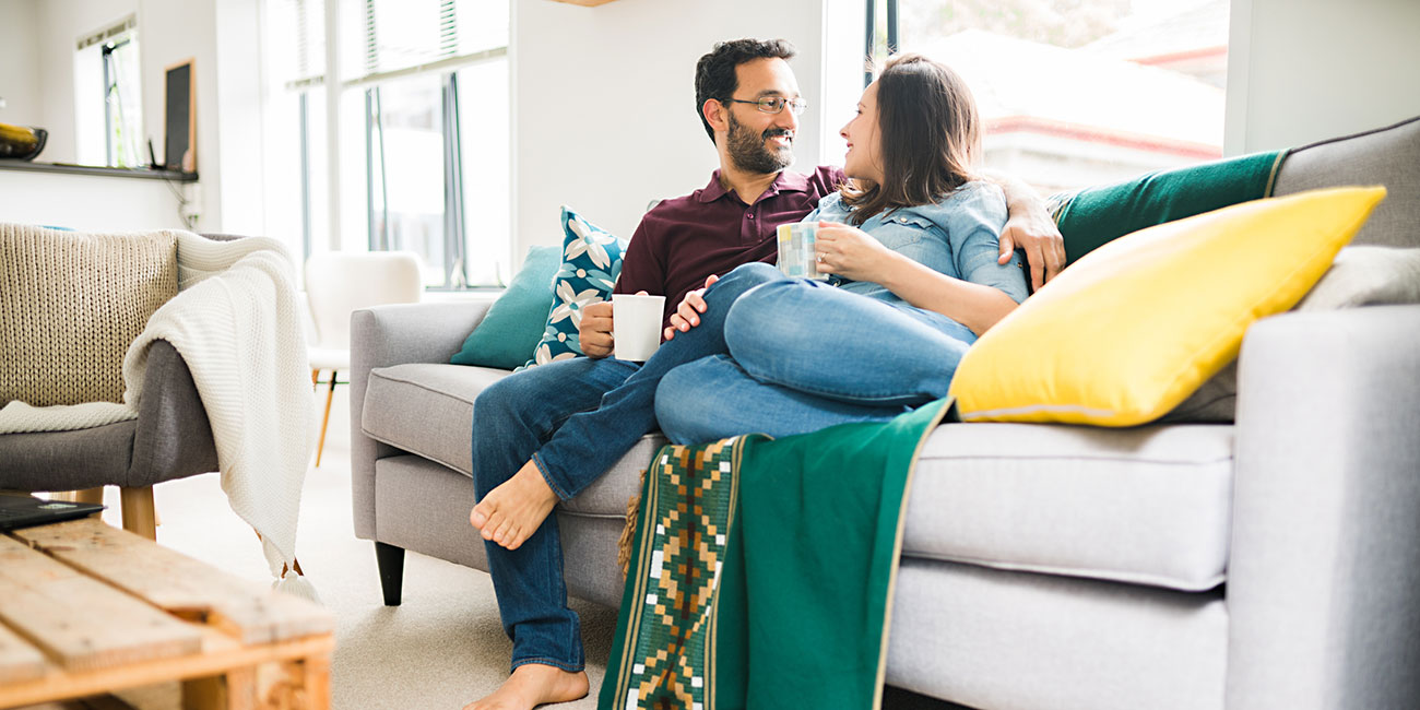 Playful hispanic canadian couple relaxing at home.