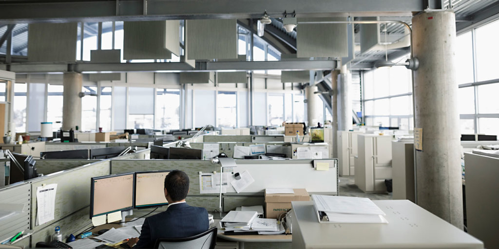 wide view of Businessman working at computers in cubicle in office cubicle