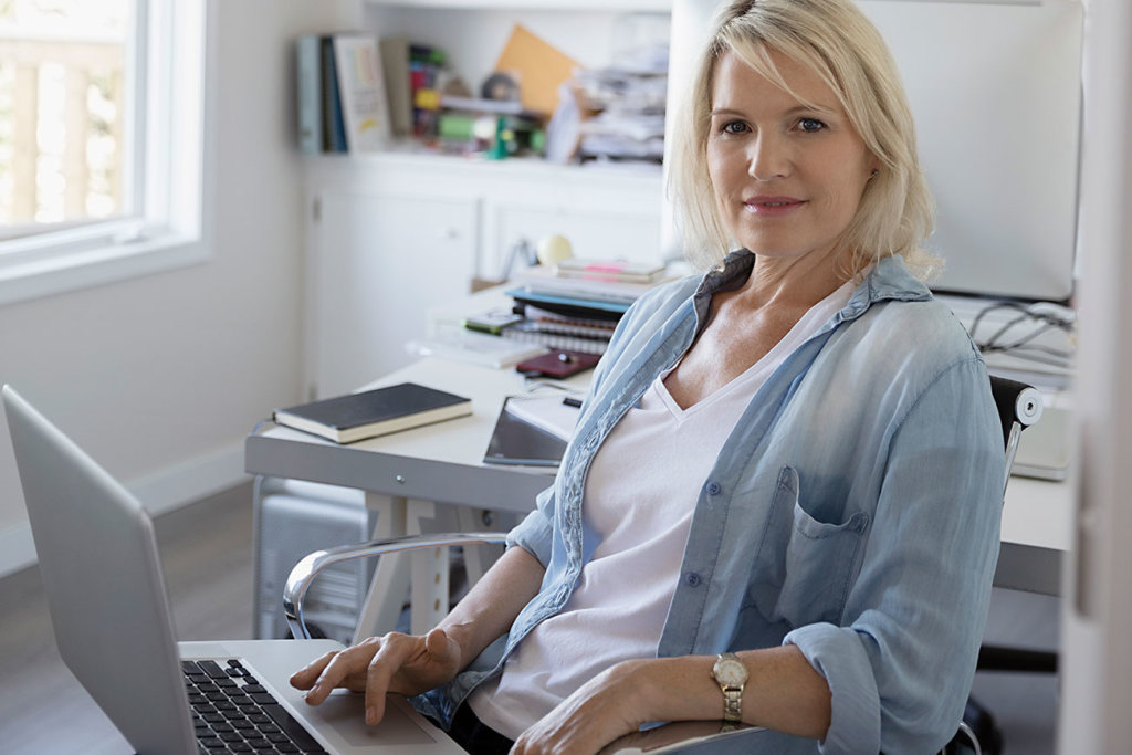 portrait of smiling blonde woman with a computer laptop