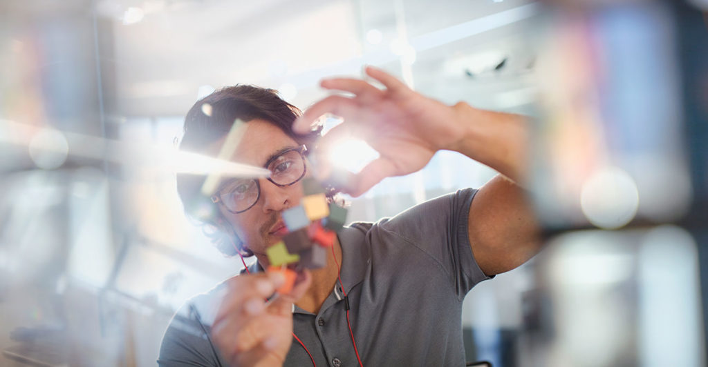 Focused, innovative male entrepreneur examining prototype