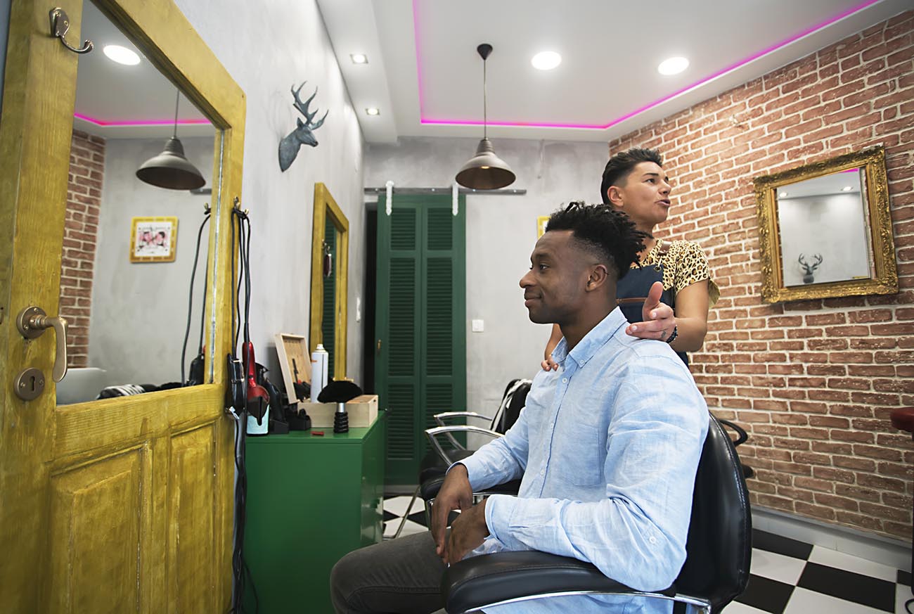 Owner and happy customer at barber shop
