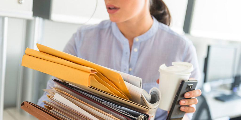 Business woman holding stack of documents in office