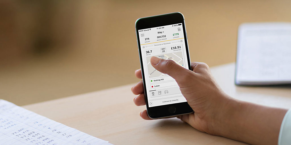 hand holding smartphone using mileiq mileage log app