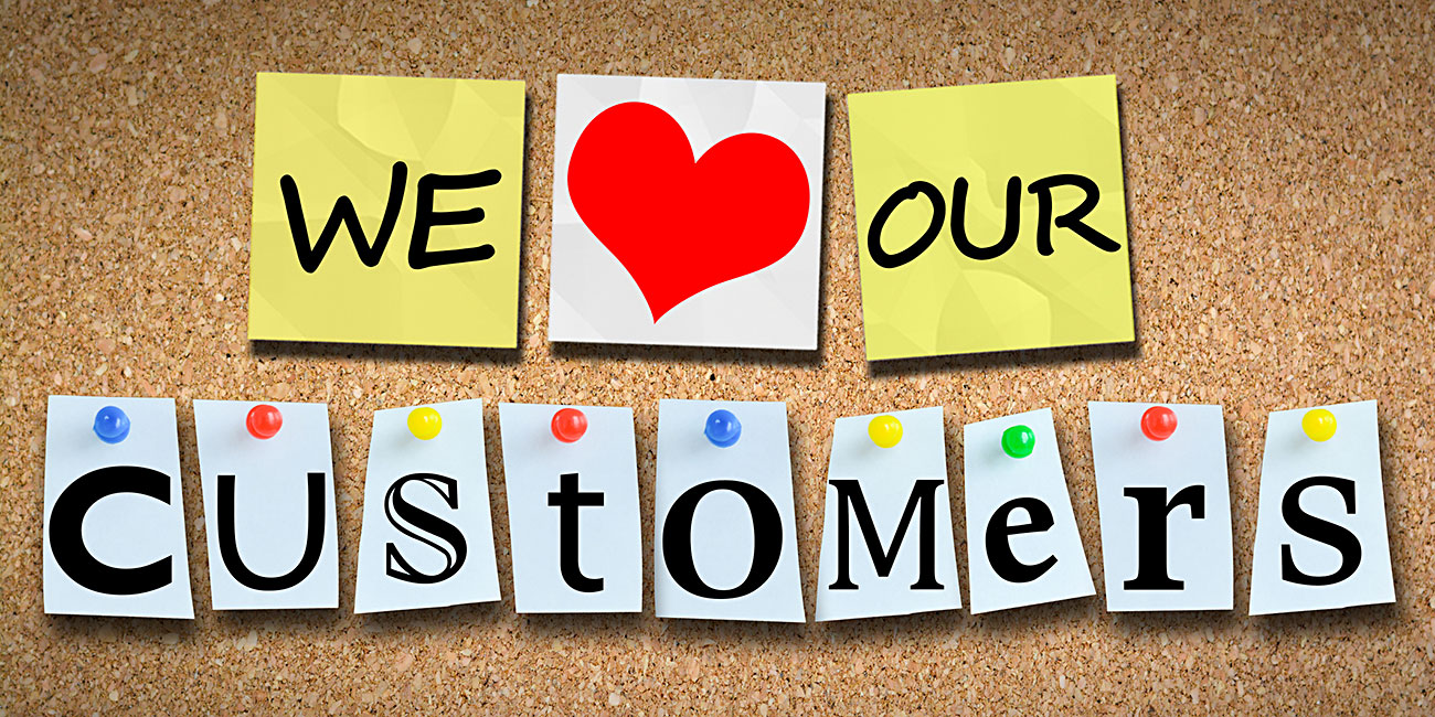 We love our customers on wooden cork billboard with pins