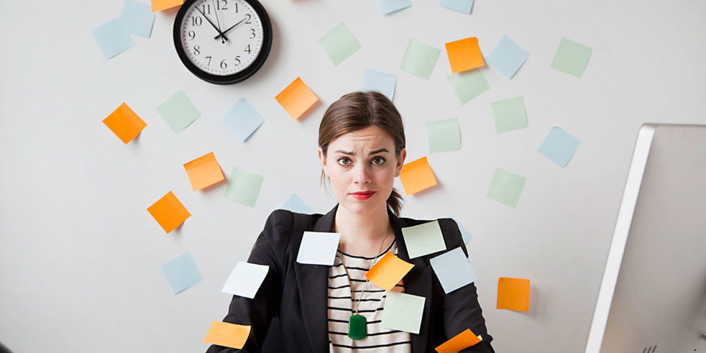 Studio shot of young woman working in office covered with sticky notes