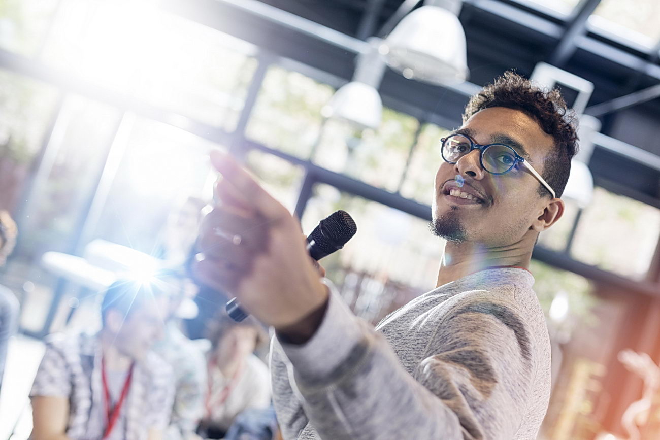 Speaker with microphone leading presentation at conference