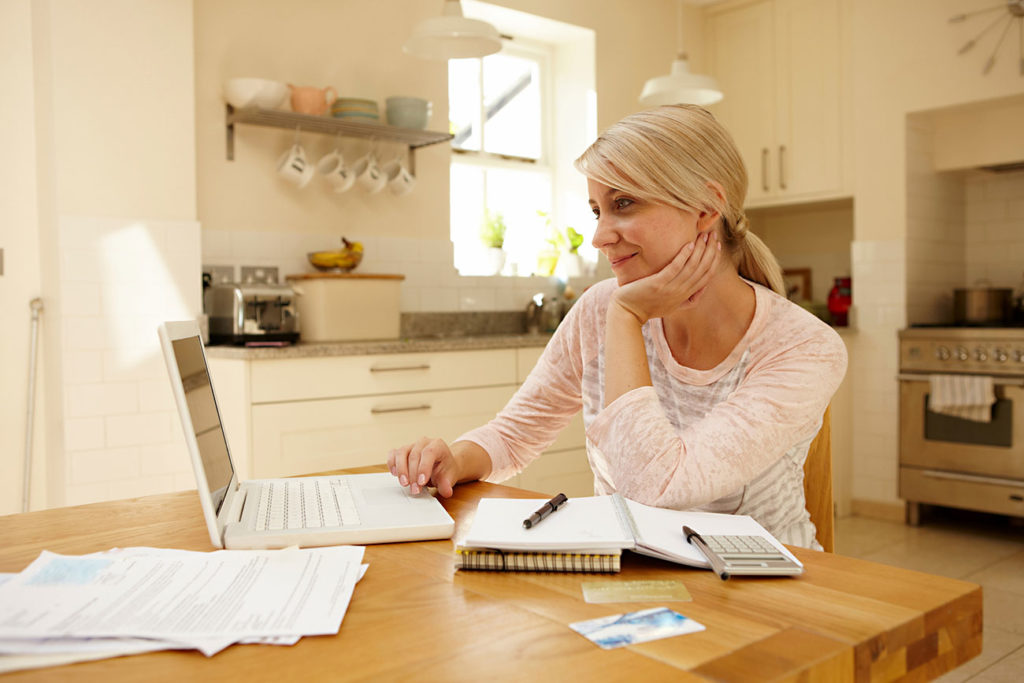 mature woman managing her business bank account on a laptop