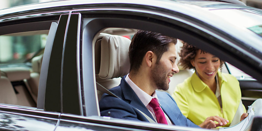 Business people logging their business miles in car