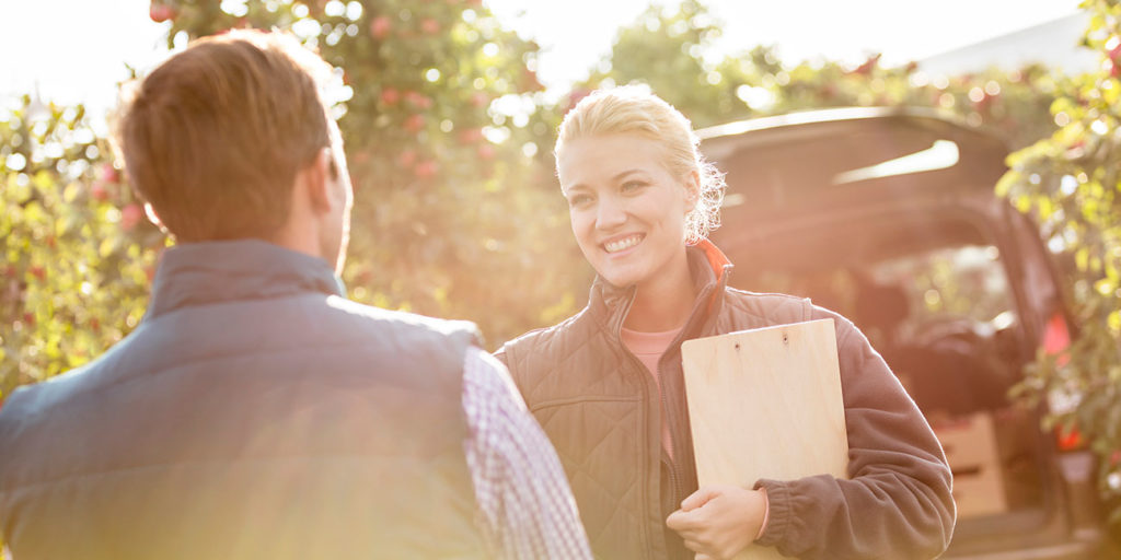 Female farmer shaking hands with produce buyer