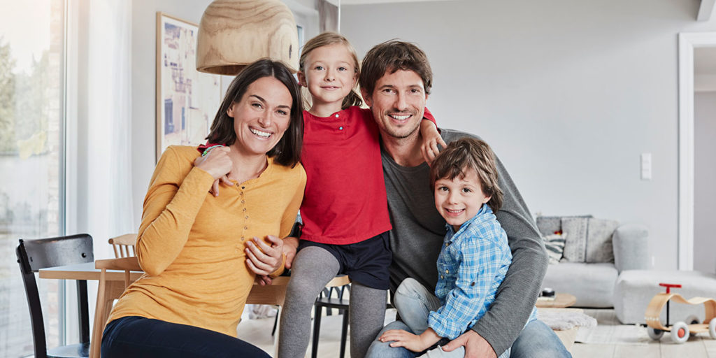 Portrait of happy family with two kids at home
