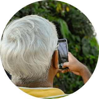 older man with grey hair checking his phone for Conpago notifications