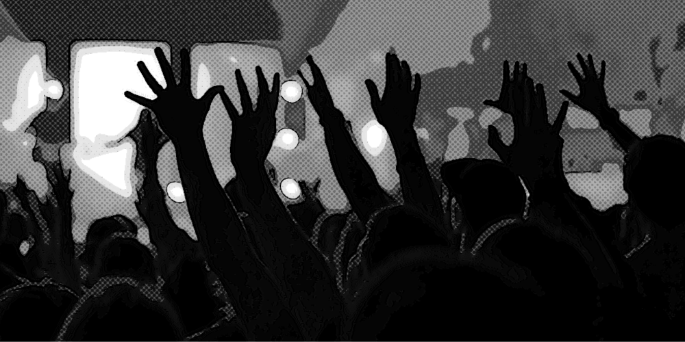 An audience at a rock concert with raised hands