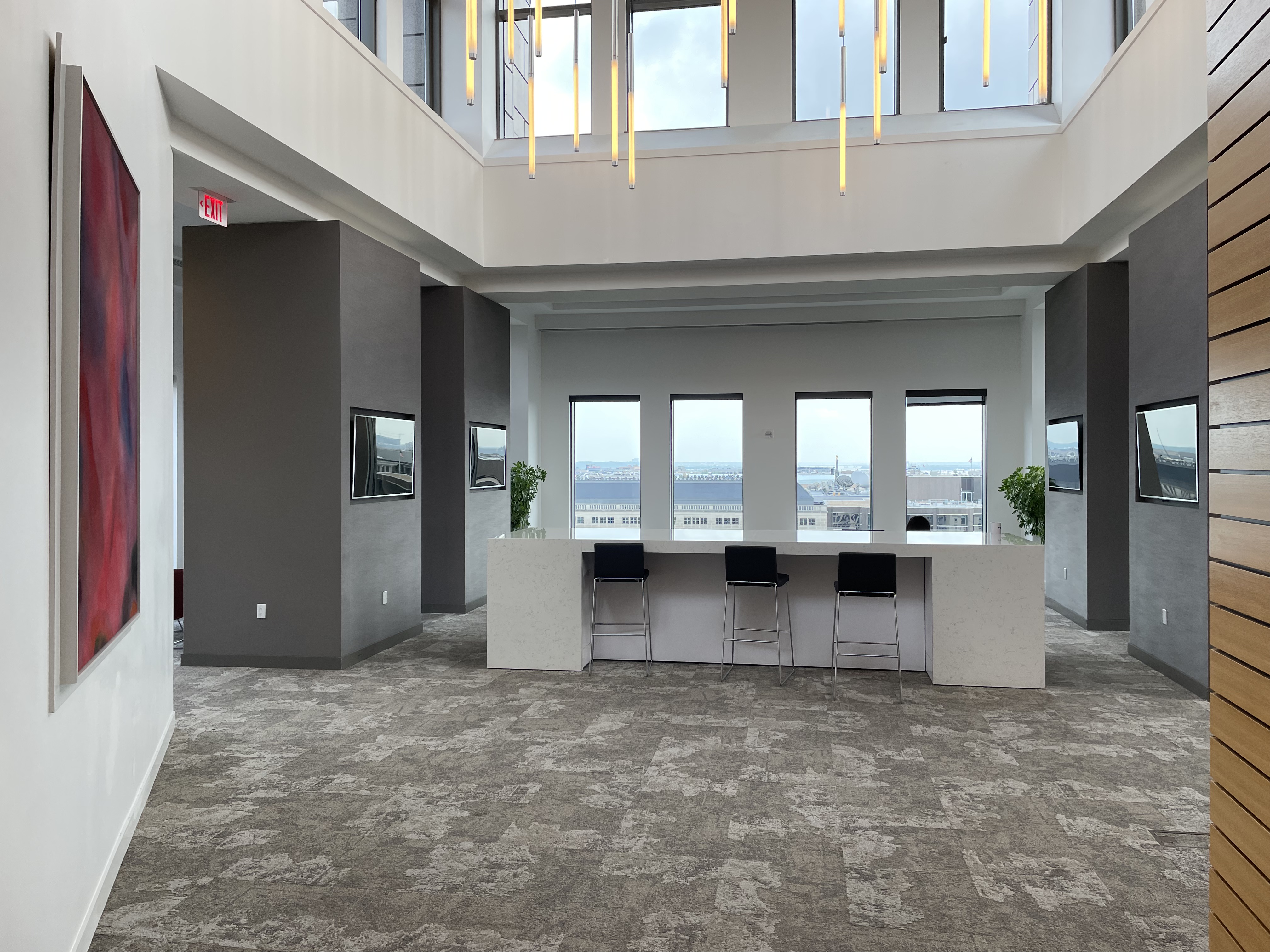 Penthouse with televisions, hanging lights, and crisp white walls