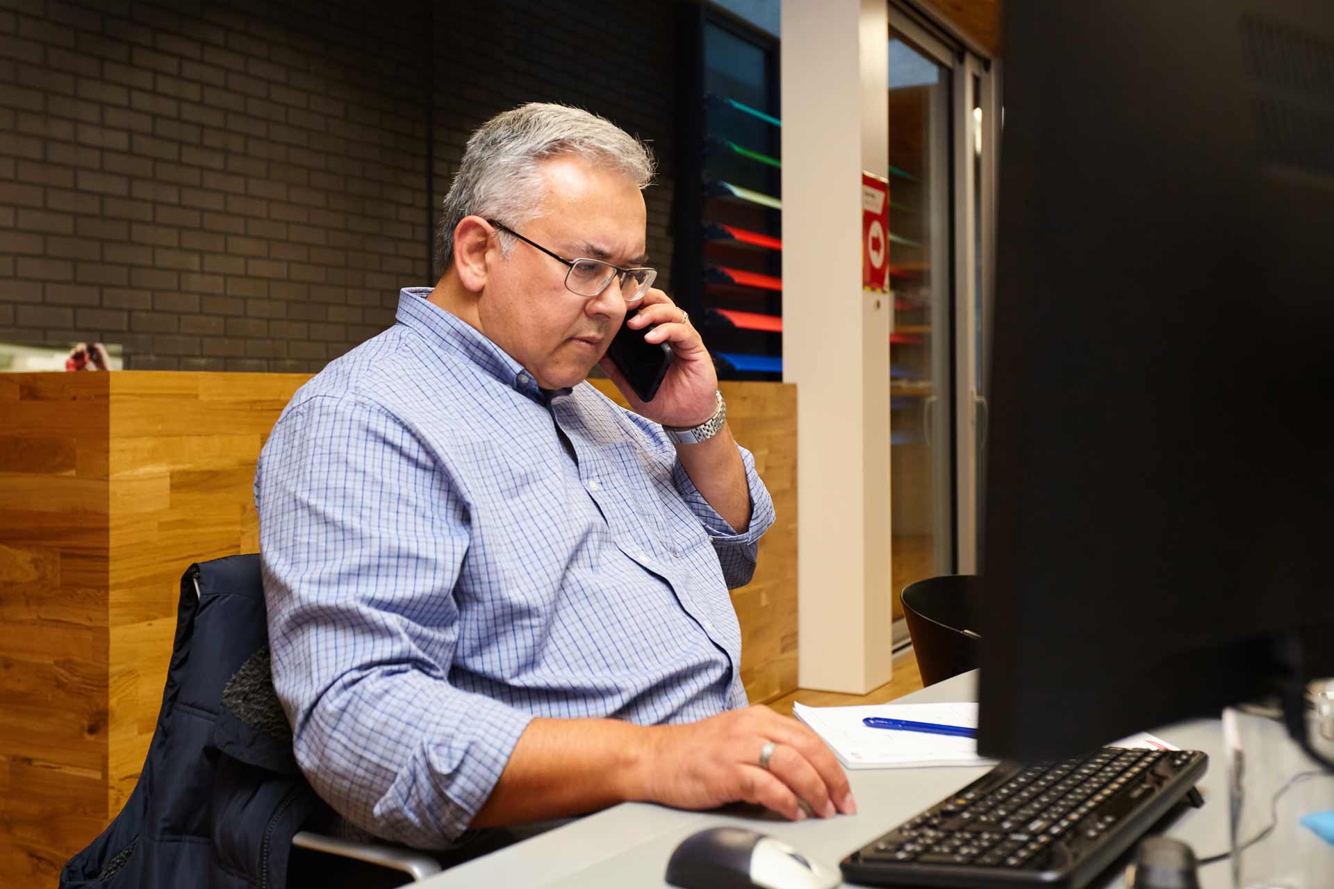 A professional answering a phone in a modern design studio in London