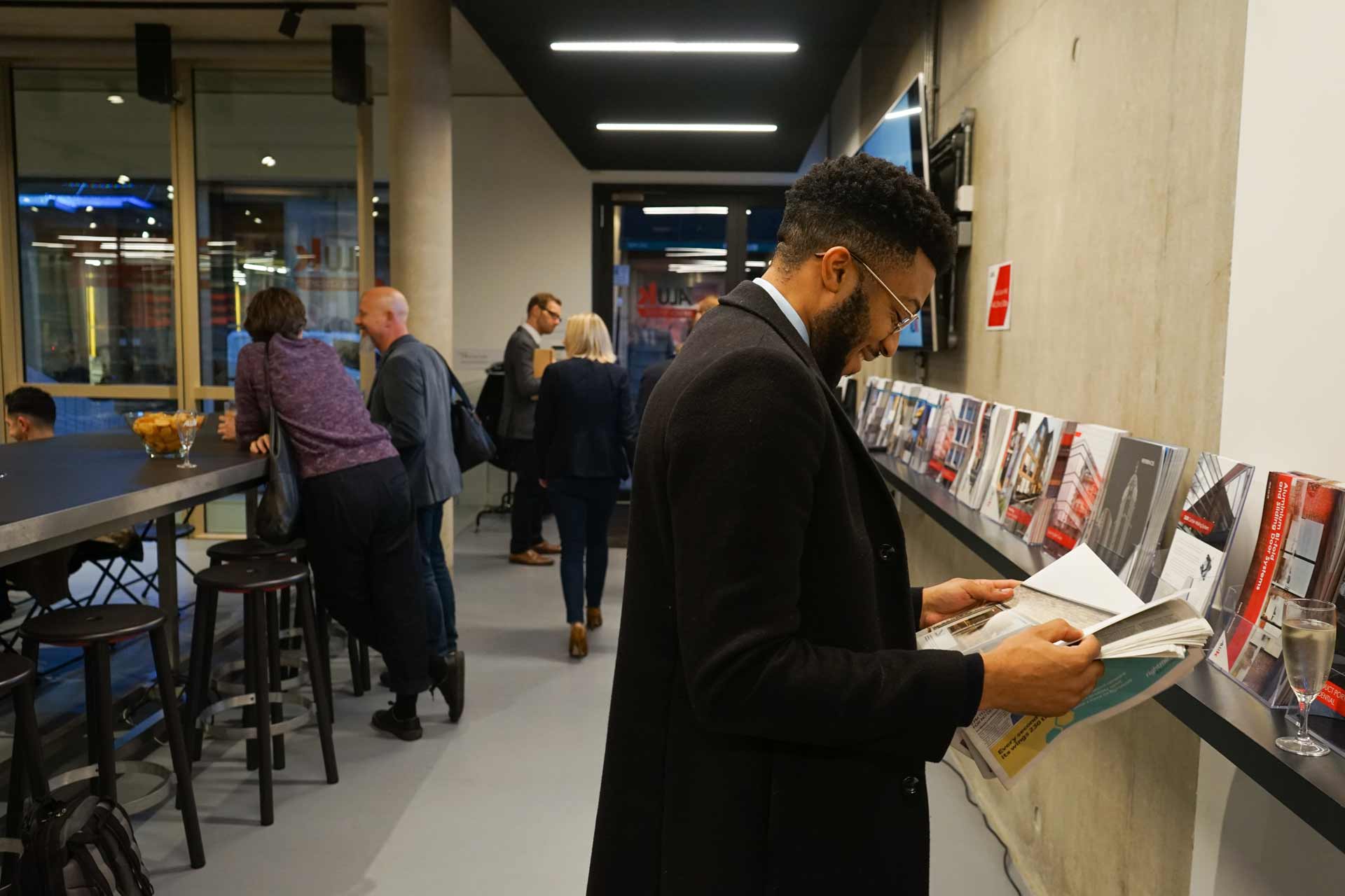 A man reading a brochure in the AluK Design Studio